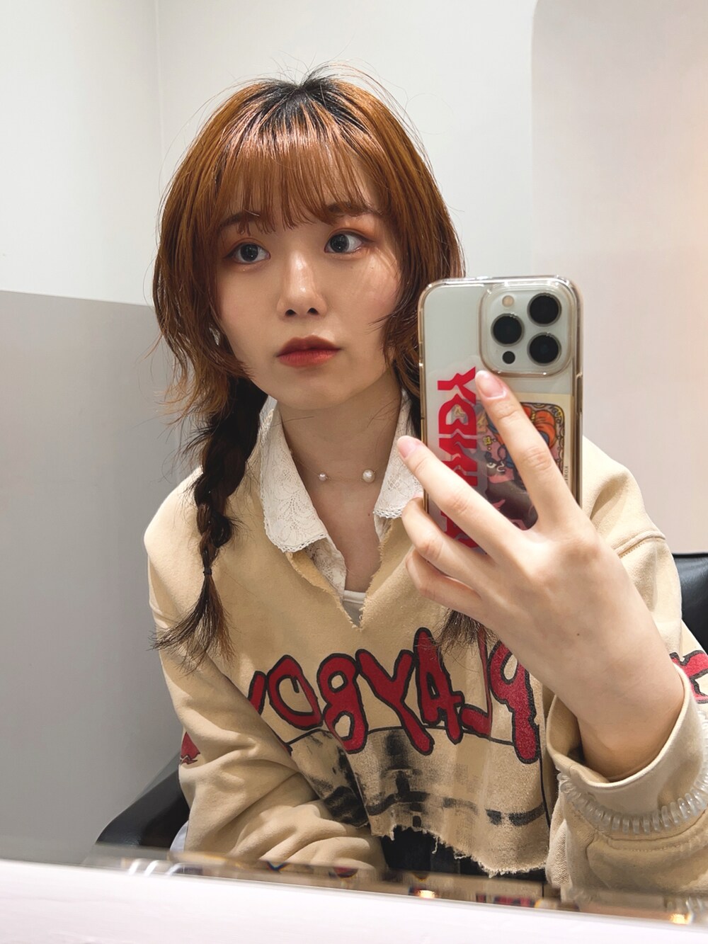 ベージュ系のスウェット、ホワイト系のシャツ/ブラウス、ピンク系のデニムパンツを着用したレディースの春コーディネートの2枚目の写真