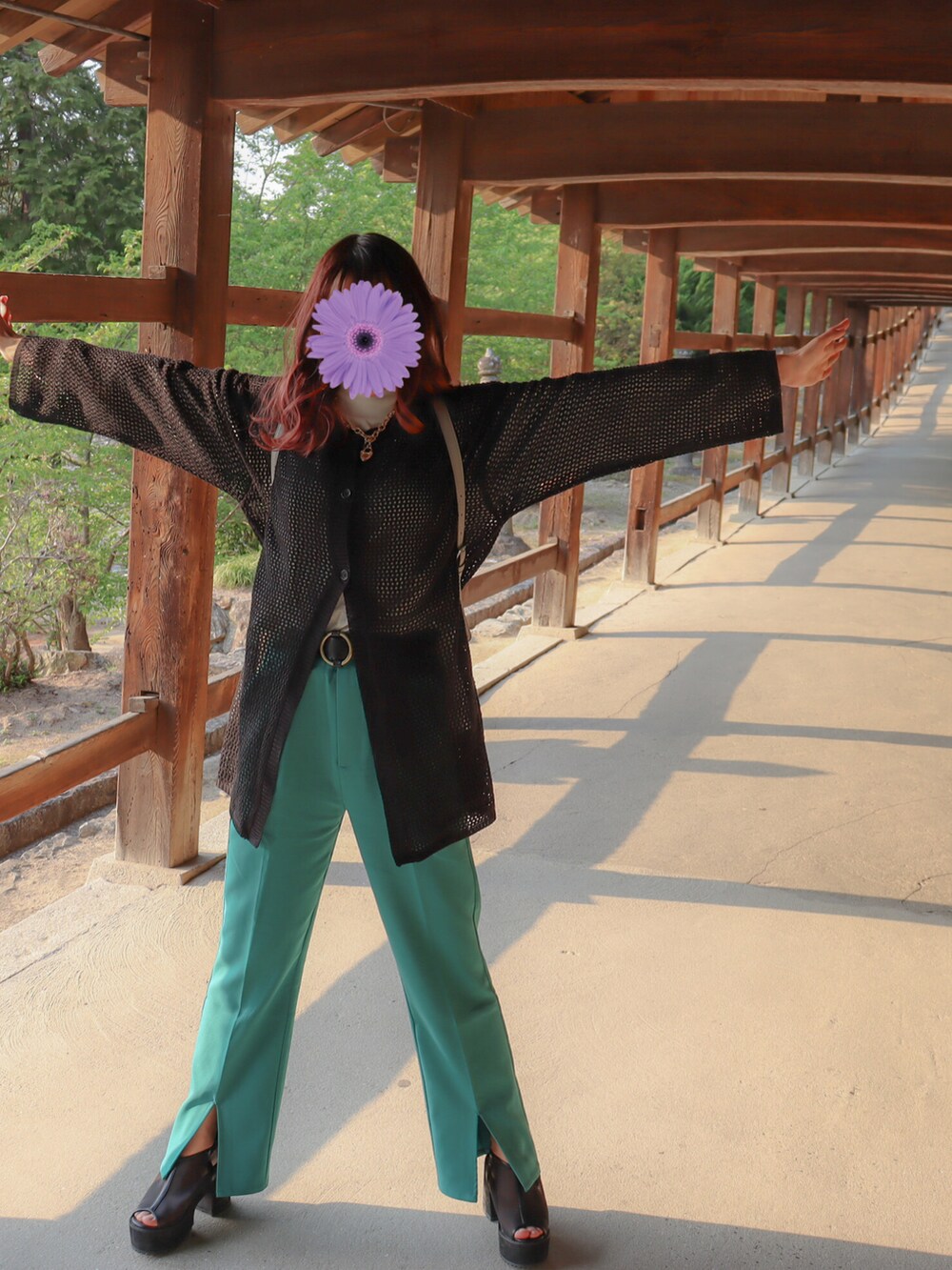 ブラック系のカーディガン/ボレロ、グレー系のバックパック/リュック、グリーン系のスラックスを着用したレディースの春コーディネートの3枚目の写真