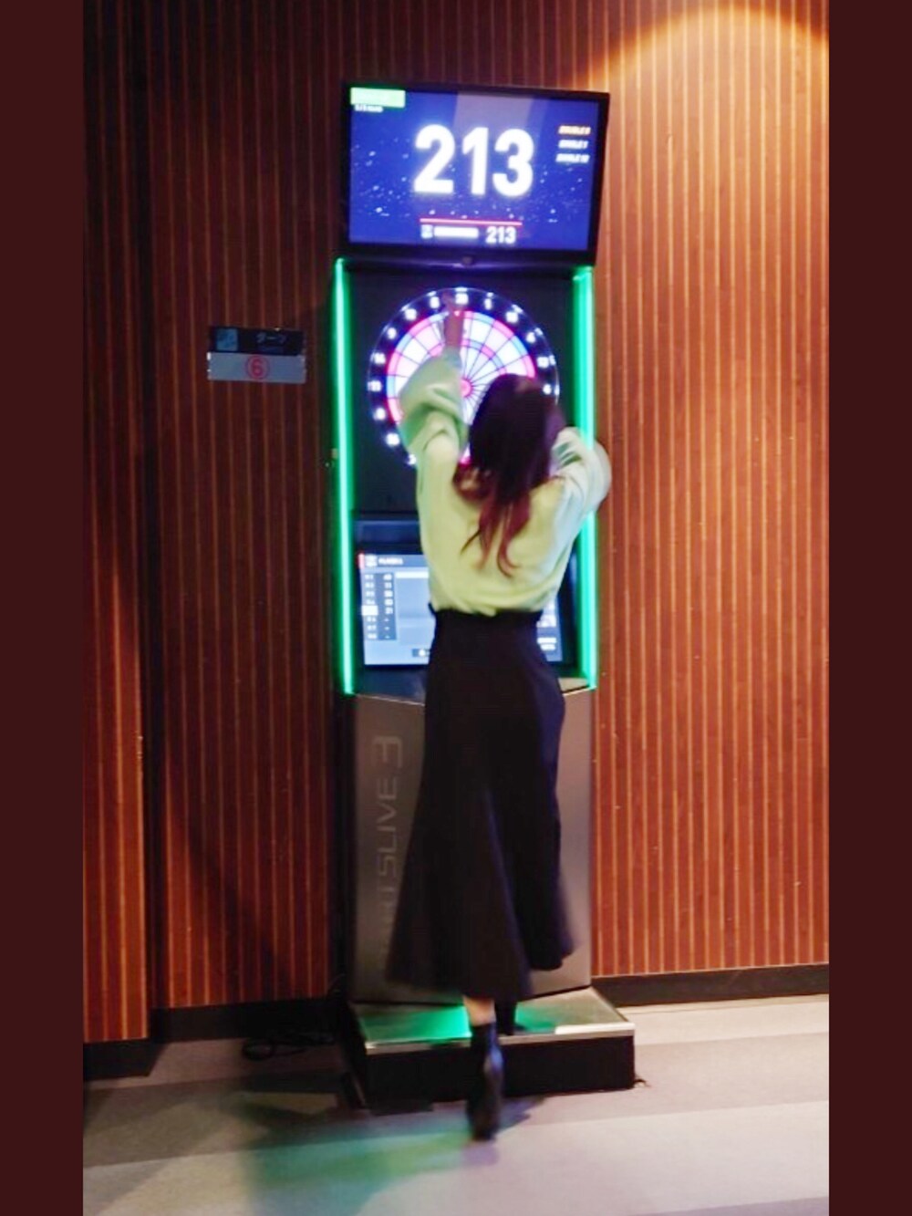 グリーン系のTシャツ/カットソー、ブラック系のスカート、ブラック系のブーツを着用したレディースの春コーディネートの3枚目の写真