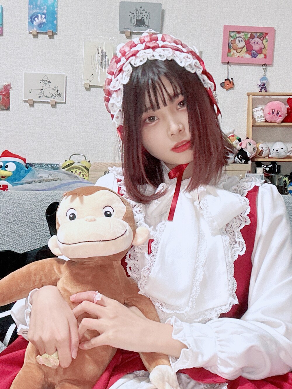 レッド系のジャンパースカート、ホワイト系のシャツ/ブラウス、ホワイト系のジャケット/アウターを着用したレディースの冬コーディネートの3枚目の写真