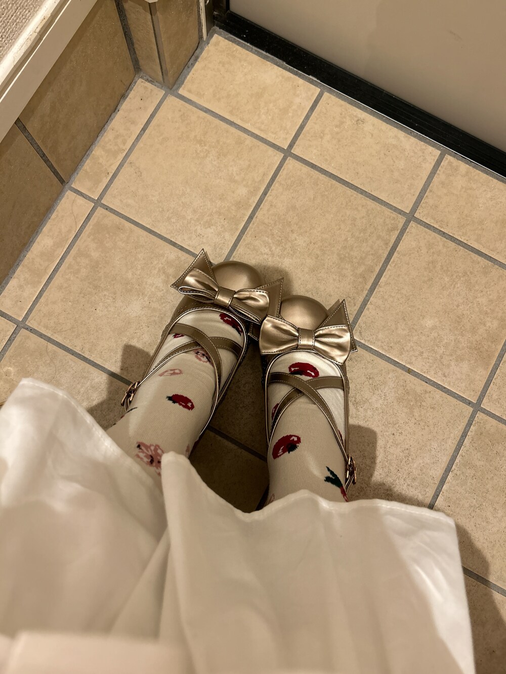 レッド系のジャンパースカート、ホワイト系のシャツ/ブラウス、ホワイト系のジャケット/アウターを着用したレディースの冬コーディネートの2枚目の写真