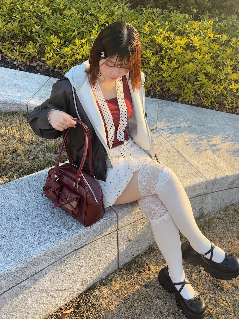 レッド系のTシャツ/カットソー、ホワイト系のスカート、ホワイト系のネクタイを着用したレディースの春コーディネートの2枚目の写真