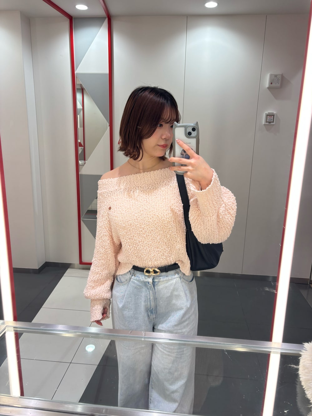 ピンク系のニット/セーター、ブルー系のデニムパンツ、ブラック系のベルトを着用したレディースの冬コーディネートの2枚目の写真