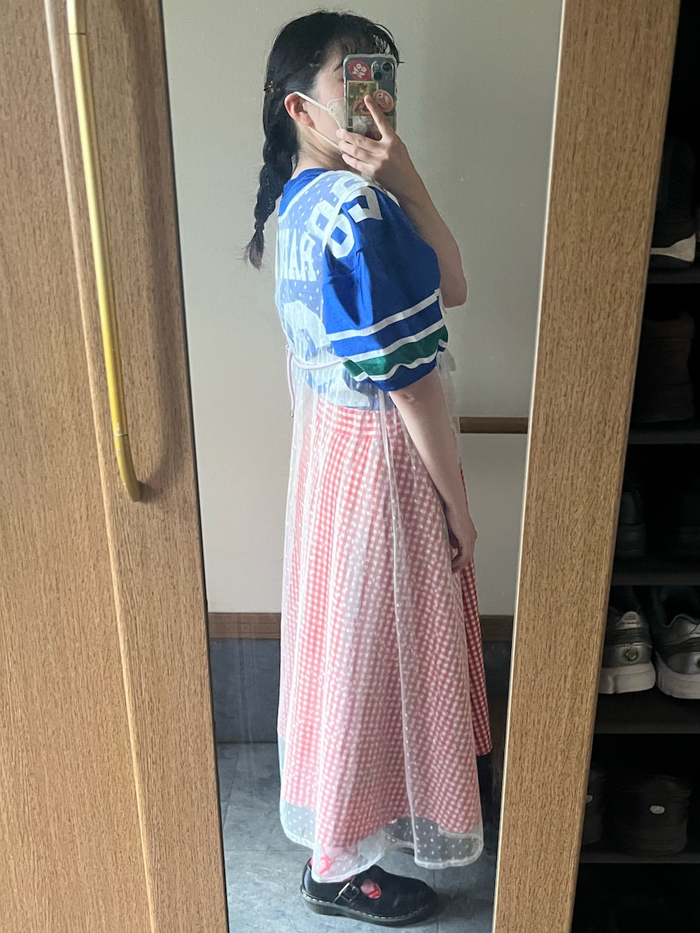 レッド系のスカート、ブラック系のローファーを着用したレディースの夏コーディネートの2枚目の写真