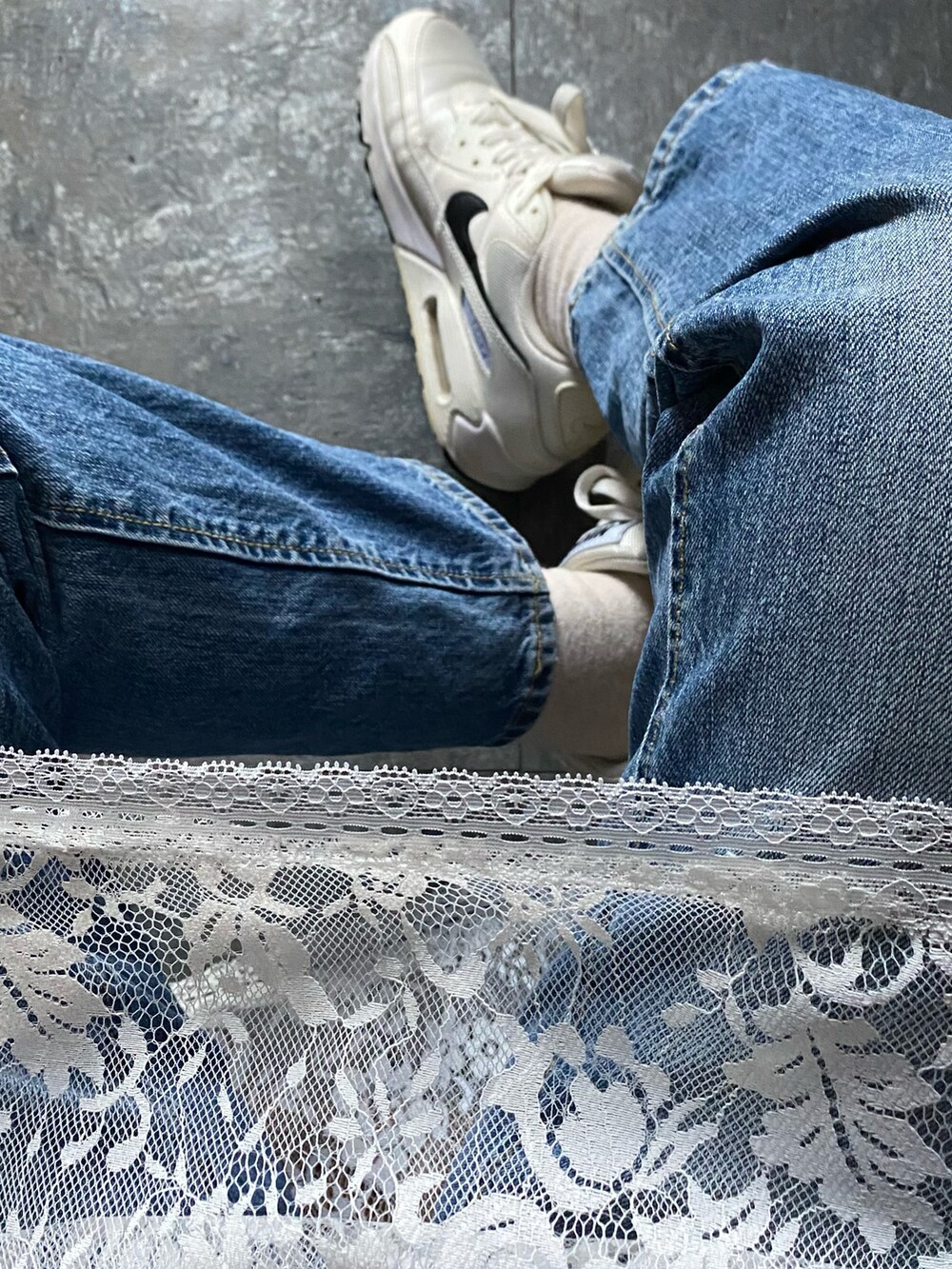 ブルー系のデニムジャケット、ブルー系のデニムパンツ、ホワイト系のスニーカーを着用したレディースの春コーディネートの2枚目の写真
