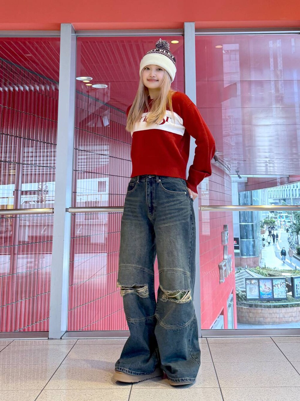 レッド系のニット/セーター、ブルー系のその他パンツ、グレー系のニットキャップ/ビーニーを着用したレディースの冬コーディネートの2枚目の写真