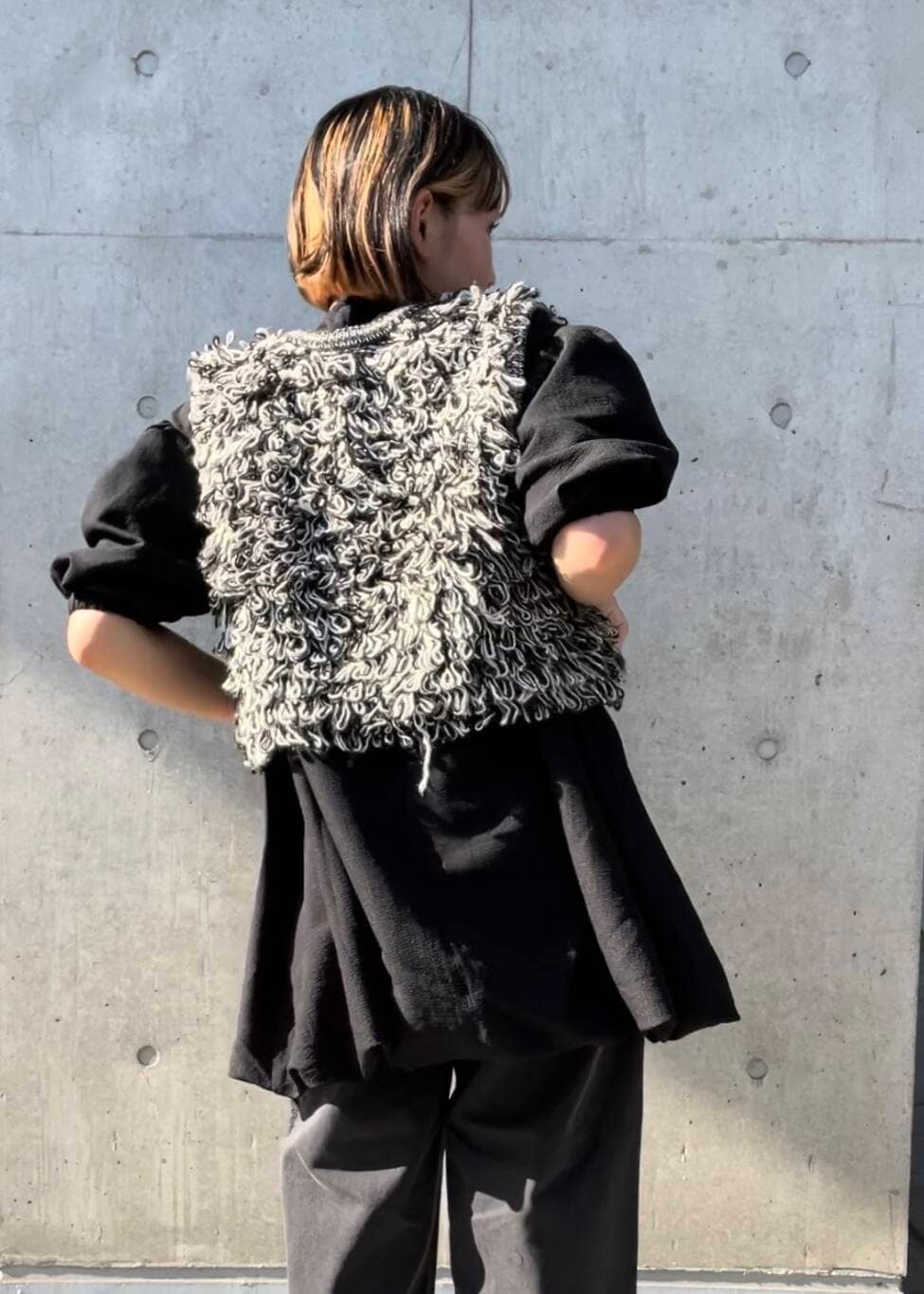 ブラック系のサンダル、ブラック系のベスト、ブラック系のデニムパンツを着用したレディースの夏コーディネートの6枚目の写真