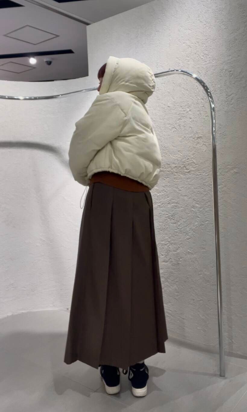 ホワイト系のダウンジャケット/コート、ブラウン系のニット/セーター、ブラウン系のワンピースを着用したレディースの冬コーディネートの3枚目の写真