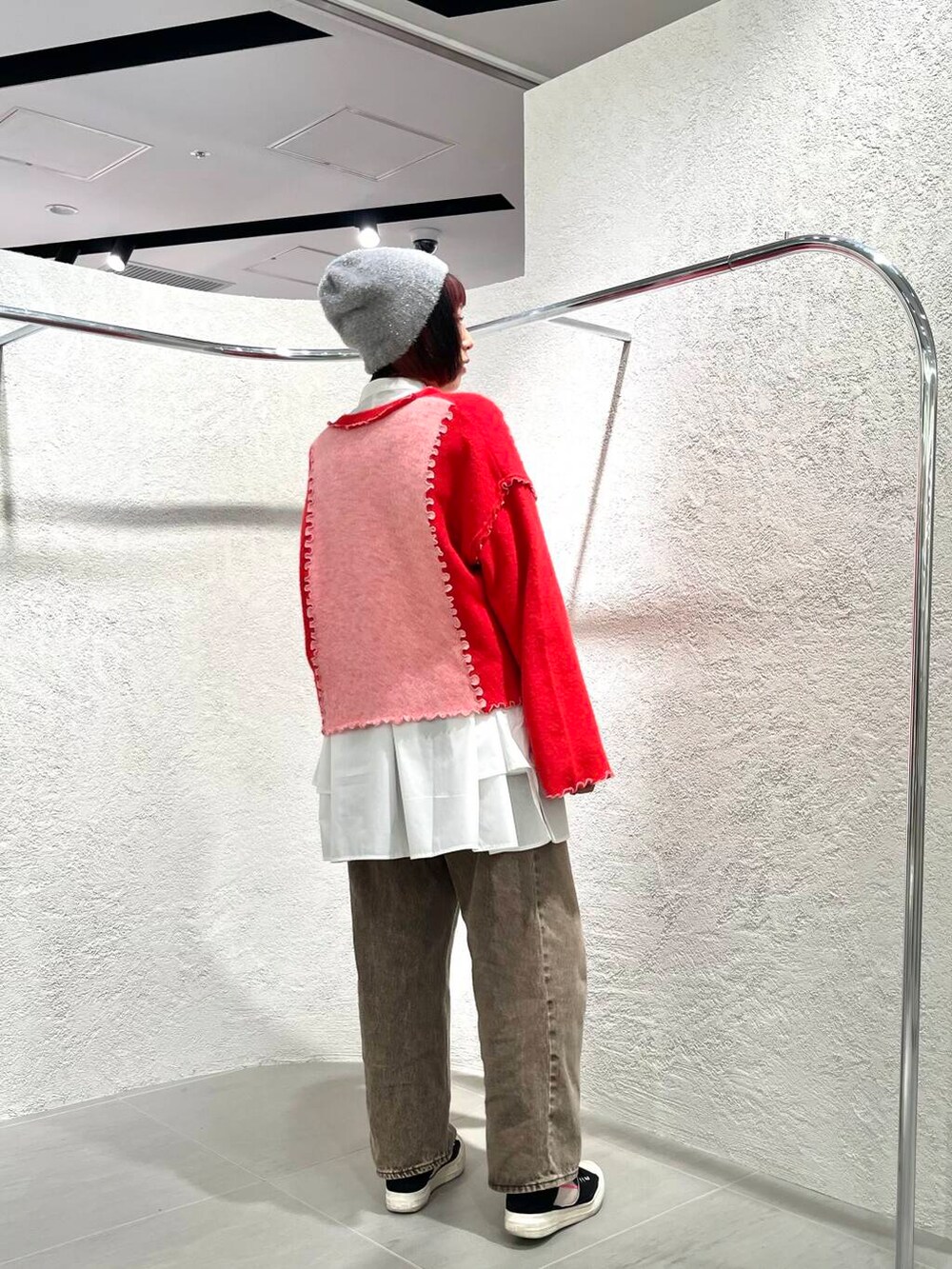 ホワイト系のワンピース、ブラウン系のデニムパンツ、ピンク系のニット/セーターを着用したレディースの冬コーディネートの2枚目の写真