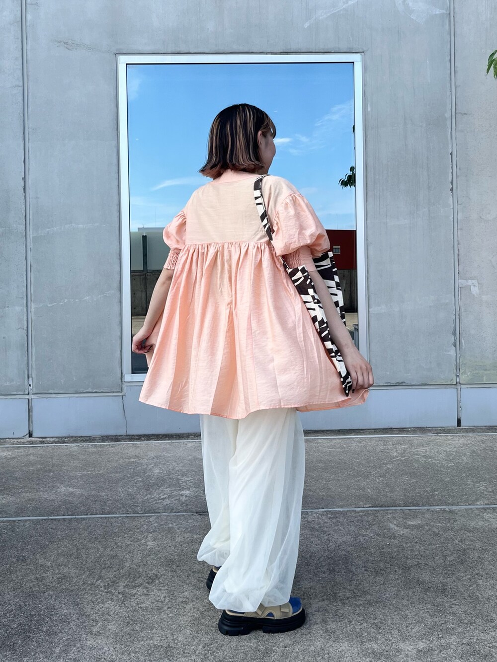 ホワイト系のその他パンツ、ベージュ系のサンダル、オレンジ系のワンピースを着用したレディースの夏コーディネートの3枚目の写真