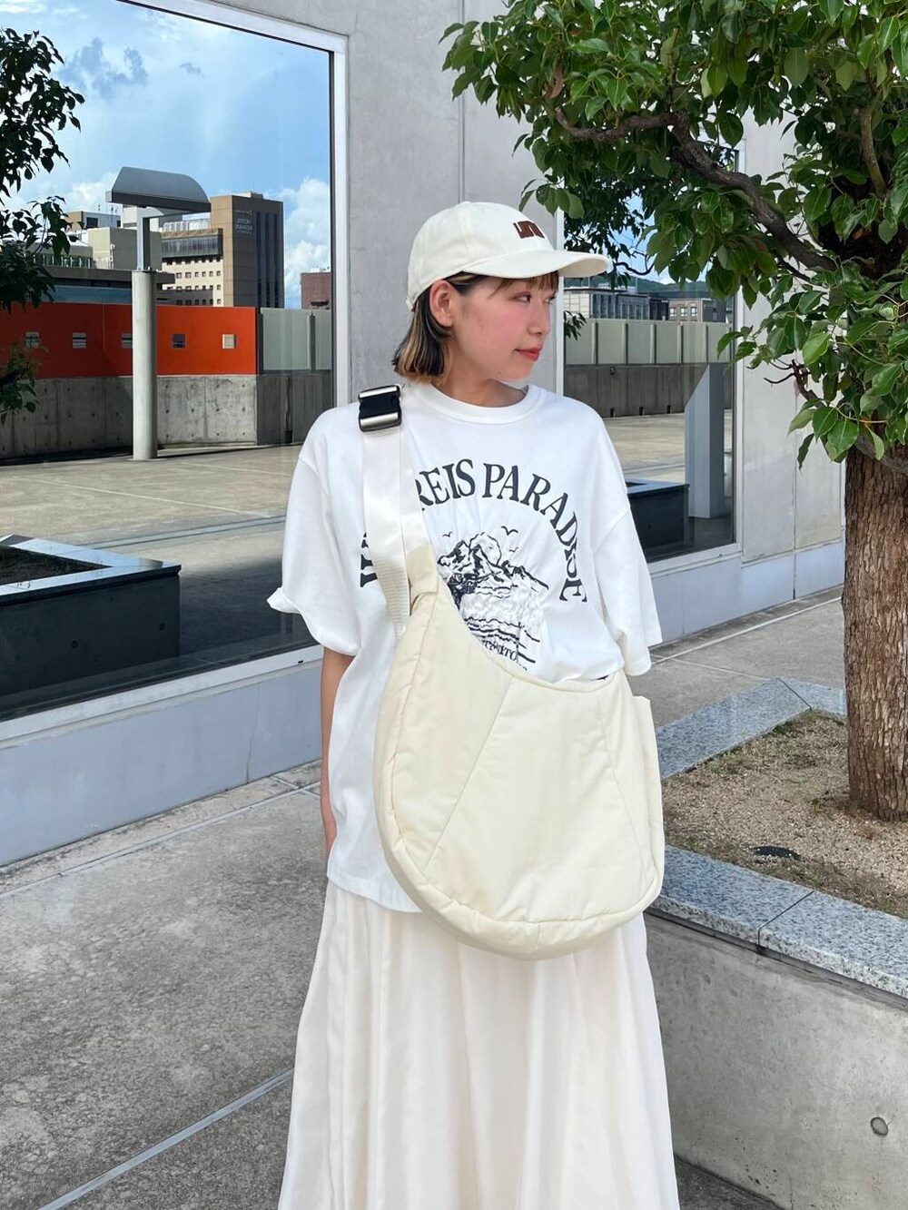 ホワイト系のサンダル、ホワイト系のショルダーバッグ、ホワイト系のTシャツ/カットソーを着用したレディースの夏コーディネートの4枚目の写真
