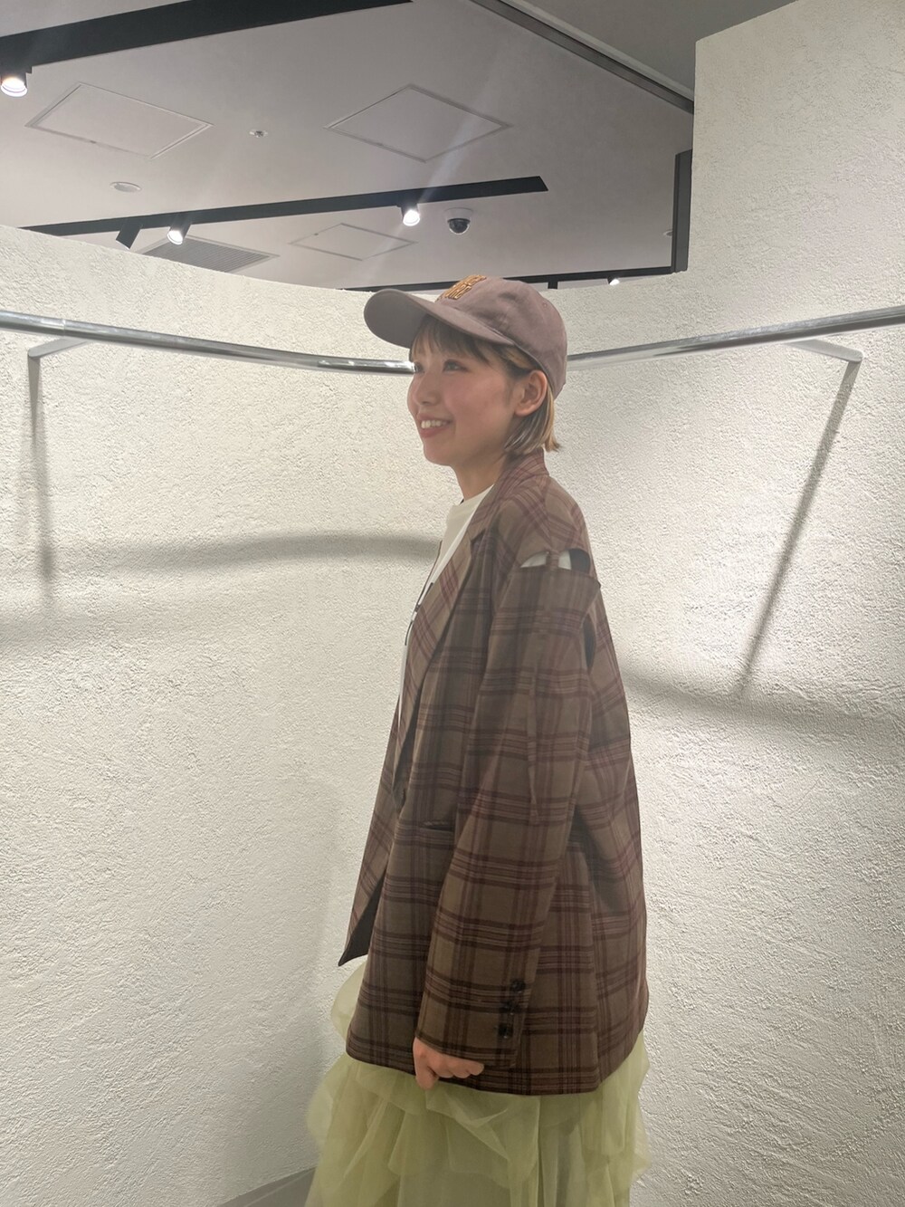 グリーン系のスカート、レッド系のその他アウター、ホワイト系のTシャツ/カットソーを着用したレディースの秋コーディネートの5枚目の写真