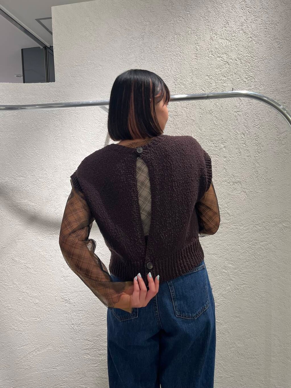 ブルー系のデニムパンツ、ブラック系のTシャツ/カットソー、ブラウン系のニット/セーターを着用したレディースの春コーディネートの7枚目の写真