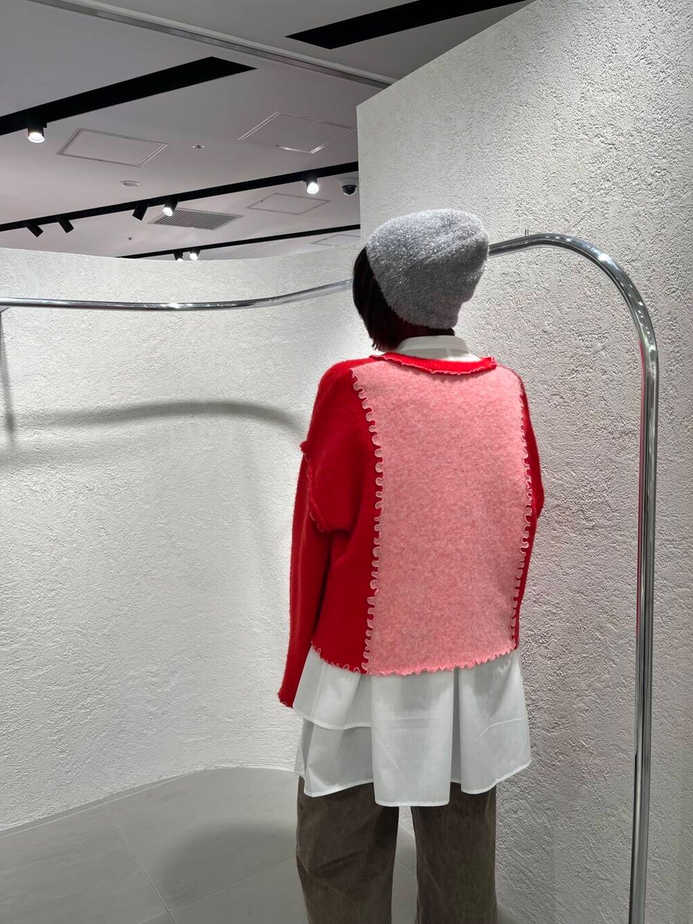 ホワイト系のワンピース、ブラウン系のデニムパンツ、ピンク系のニット/セーターを着用したレディースの冬コーディネートの6枚目の写真