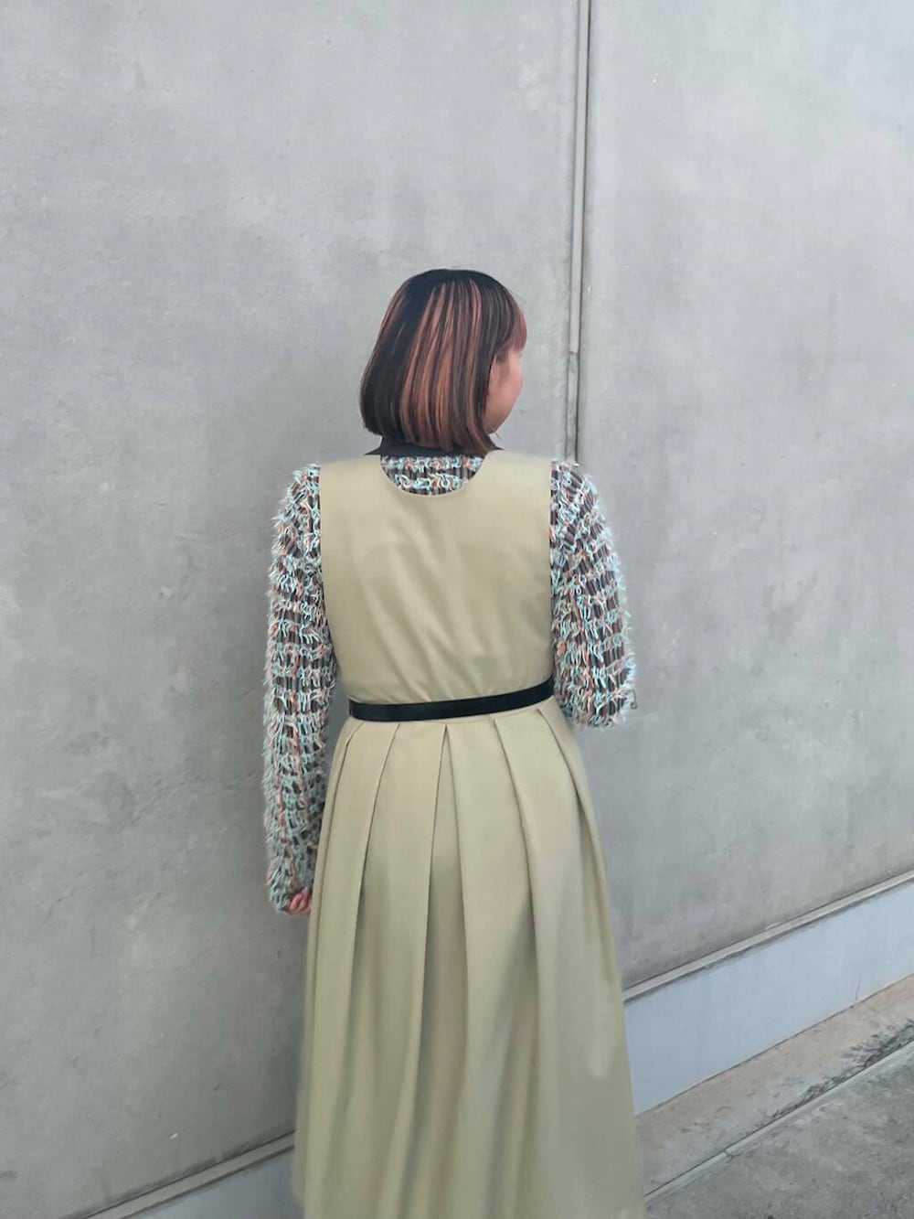 グレー系のニット/セーター、グリーン系のワンピース、ブラック系のベルトを着用したレディースの冬コーディネートの6枚目の写真