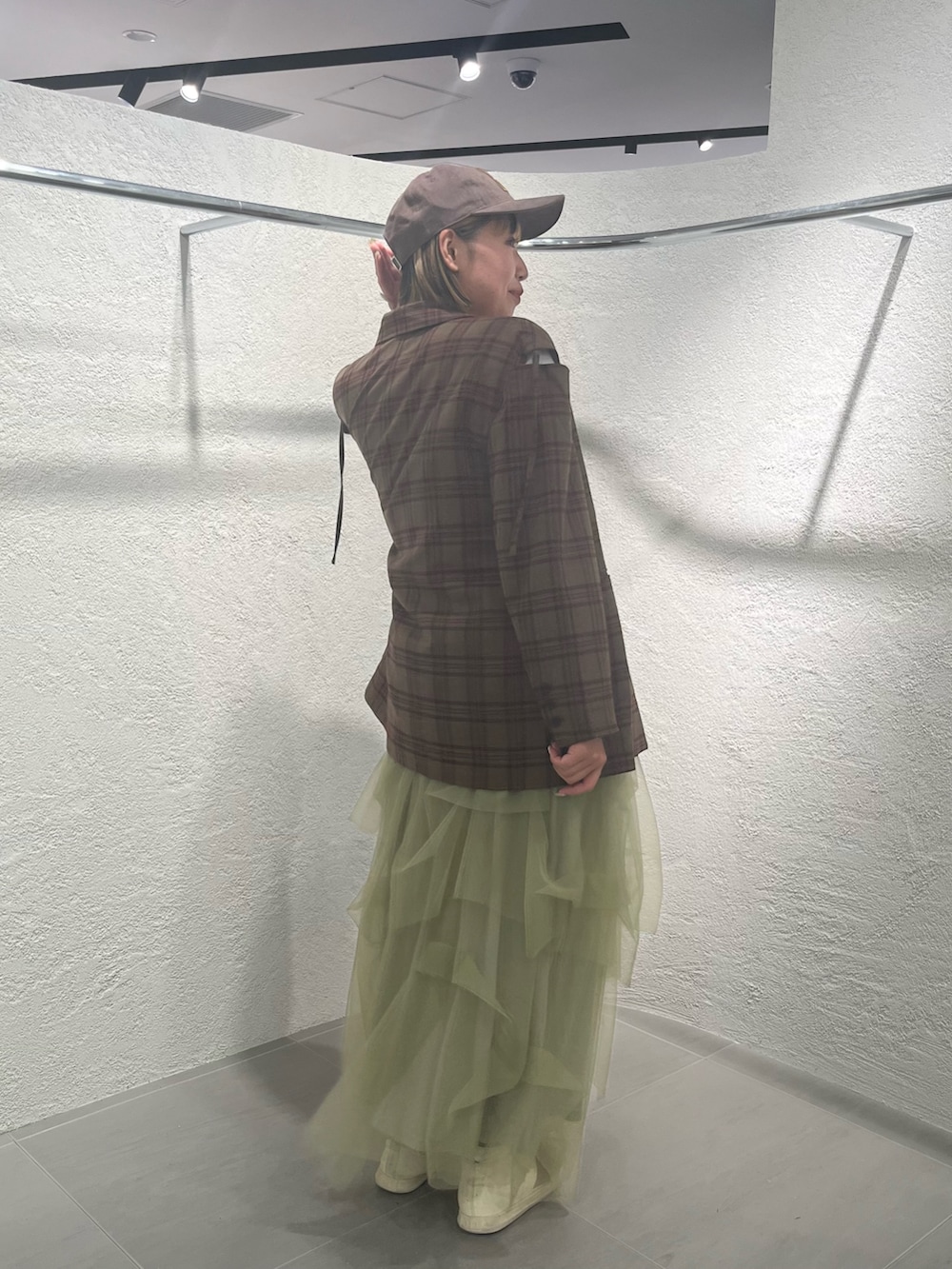 グリーン系のスカート、レッド系のその他アウター、ホワイト系のTシャツ/カットソーを着用したレディースの秋コーディネートの3枚目の写真