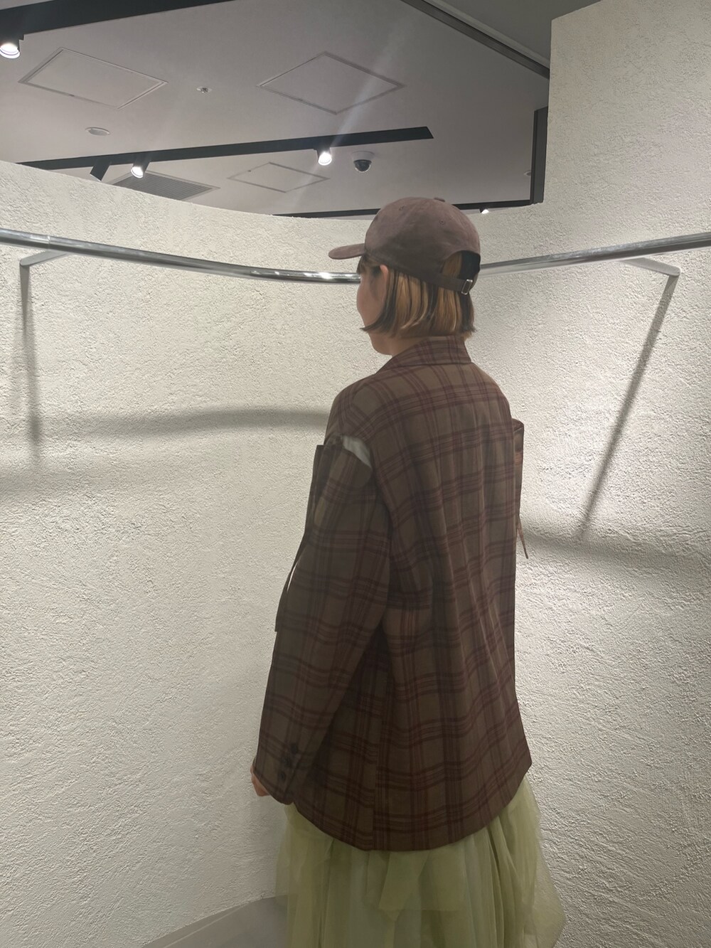 グリーン系のスカート、レッド系のその他アウター、ホワイト系のTシャツ/カットソーを着用したレディースの秋コーディネートの6枚目の写真