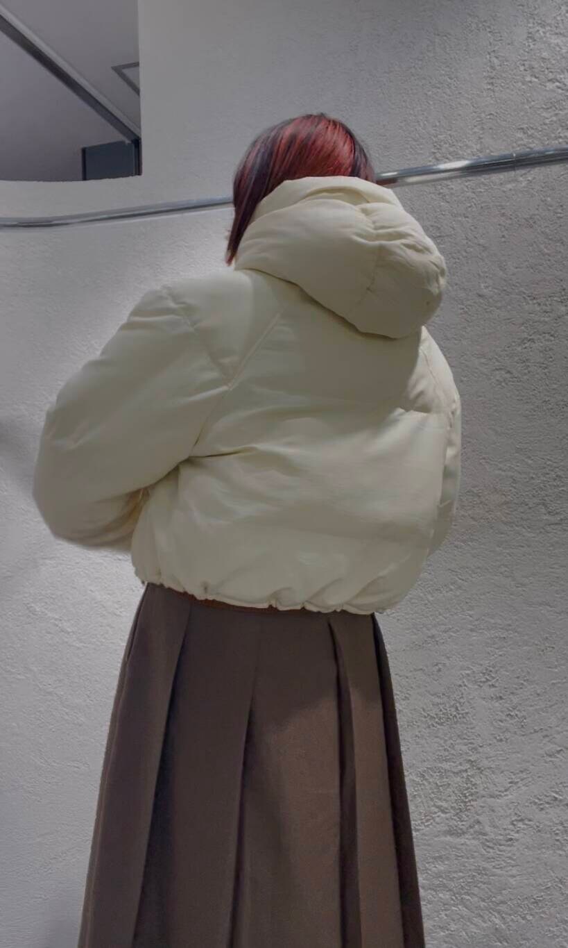 ホワイト系のダウンジャケット/コート、ブラウン系のニット/セーター、ブラウン系のワンピースを着用したレディースの冬コーディネートの6枚目の写真