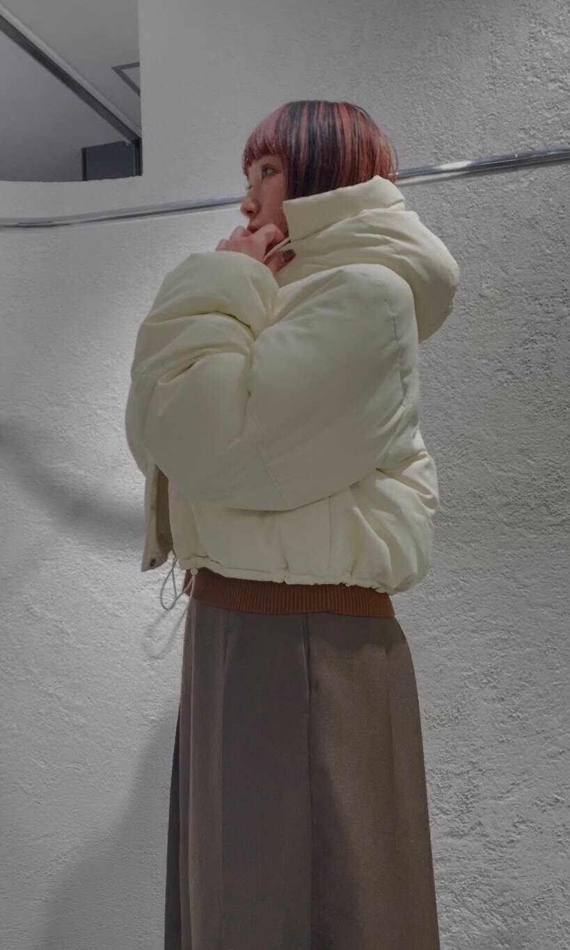 ホワイト系のダウンジャケット/コート、ブラウン系のニット/セーター、ブラウン系のワンピースを着用したレディースの冬コーディネートの5枚目の写真