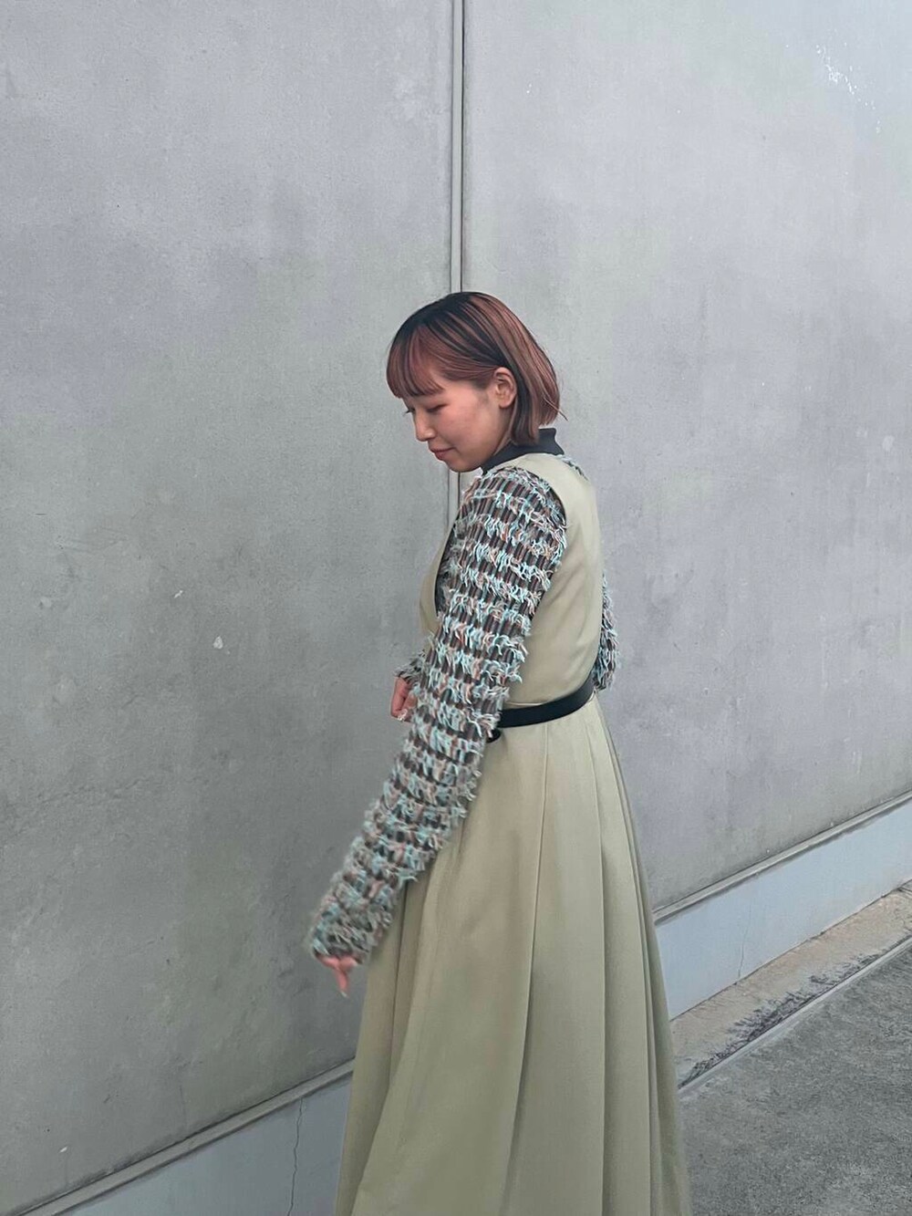 グレー系のニット/セーター、グリーン系のワンピース、ブラック系のベルトを着用したレディースの冬コーディネートの5枚目の写真