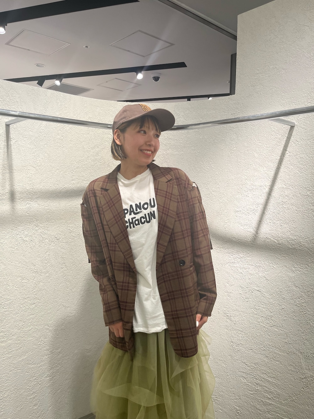 グリーン系のスカート、レッド系のその他アウター、ホワイト系のTシャツ/カットソーを着用したレディースの秋コーディネートの4枚目の写真