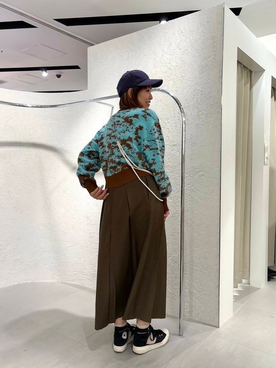 ブラウン系のニット/セーター、ブラウン系のワンピース、ブルー系のキャップを着用したレディースの冬コーディネートの3枚目の写真