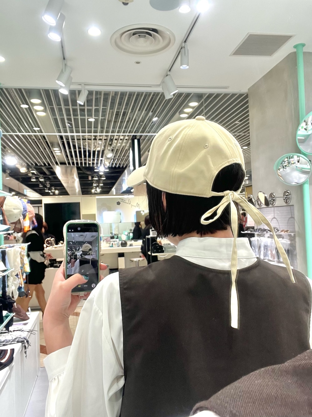 ベージュ系のキャップを着用したレディースの春コーディネートの2枚目の写真