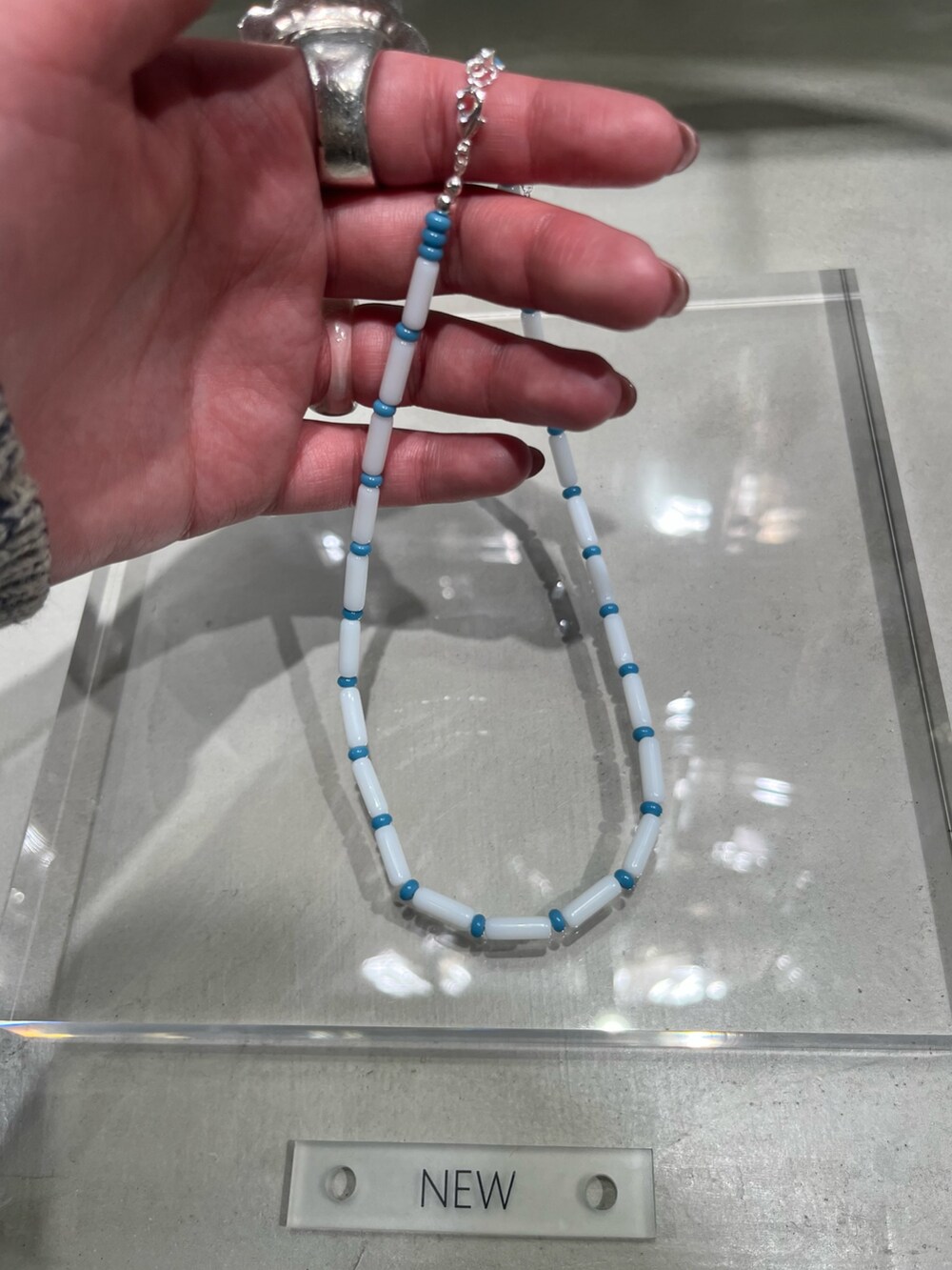 ブルー系のネックレスを着用したレディースの冬コーディネートの2枚目の写真