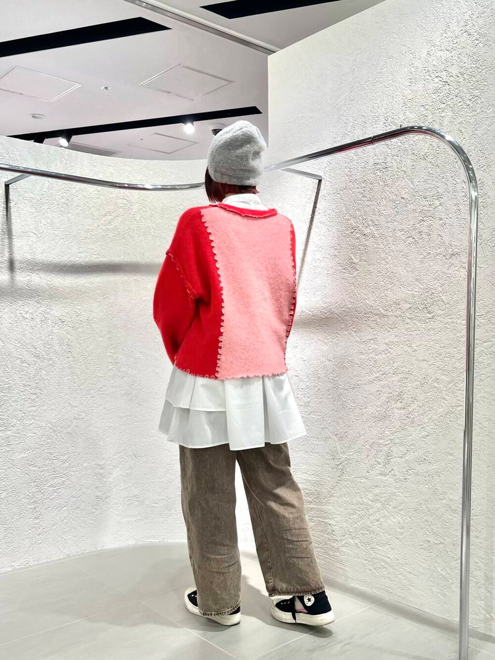 ホワイト系のワンピース、ブラウン系のデニムパンツ、ピンク系のニット/セーターを着用したレディースの冬コーディネートの3枚目の写真