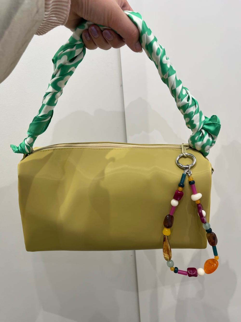 イエロー系のトートバッグ、グリーン系のバンダナ/スカーフを着用したレディースの春コーディネートの2枚目の写真