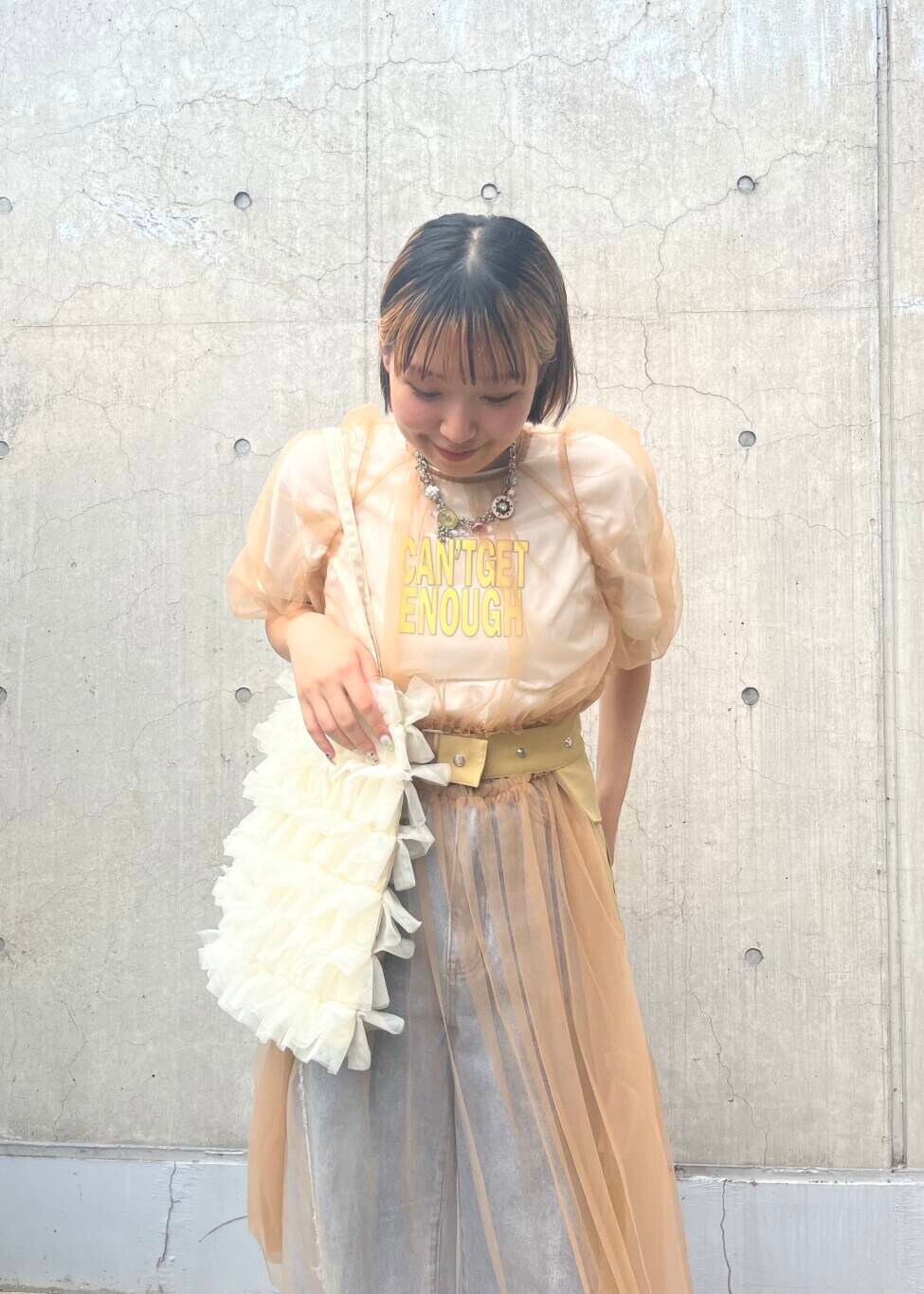 ブルー系のデニムパンツ、ホワイト系のトートバッグ、ブラック系のサンダルを着用したレディースの夏コーディネートの3枚目の写真