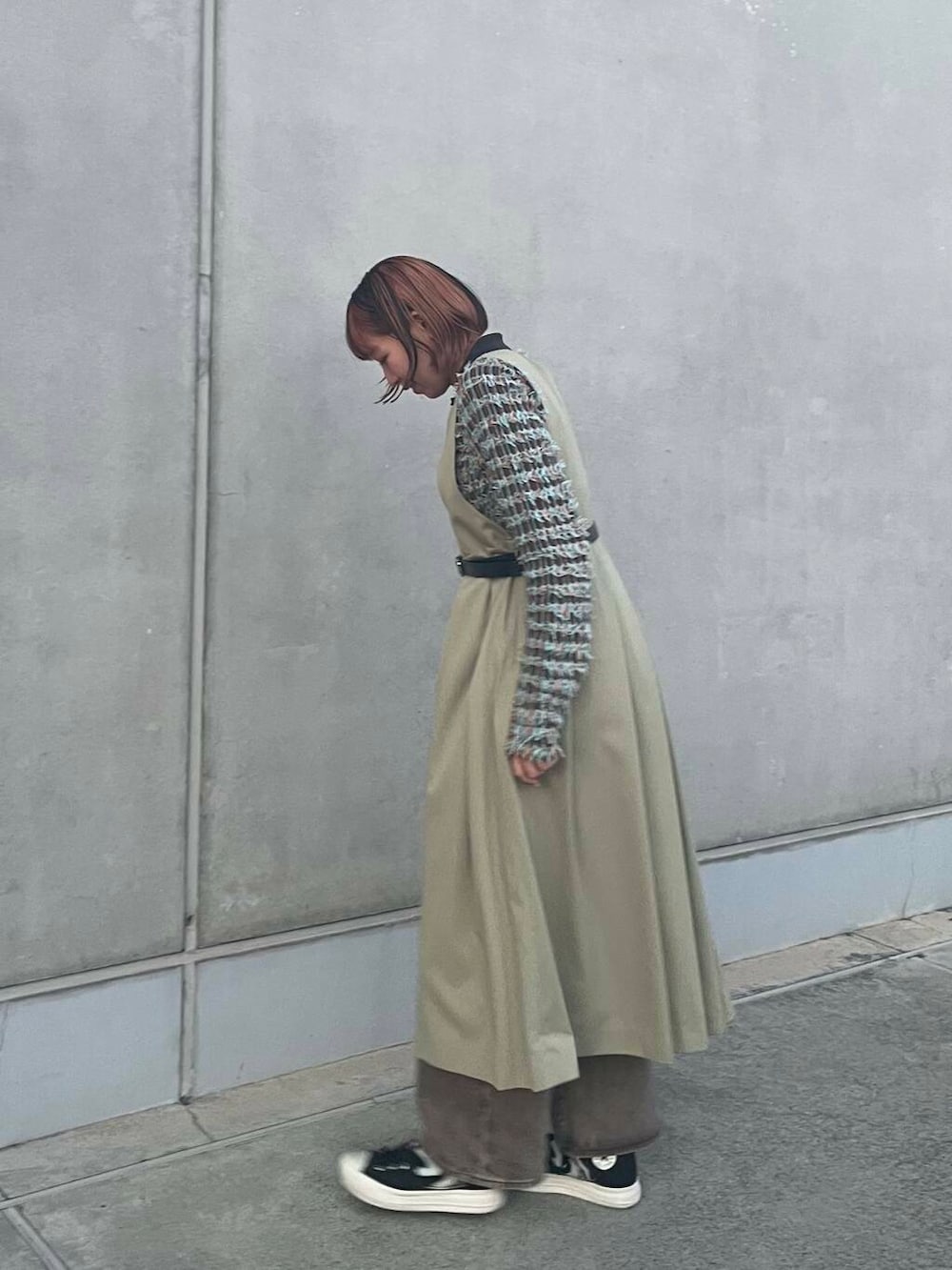 グレー系のニット/セーター、グリーン系のワンピース、ブラック系のベルトを着用したレディースの冬コーディネートの2枚目の写真