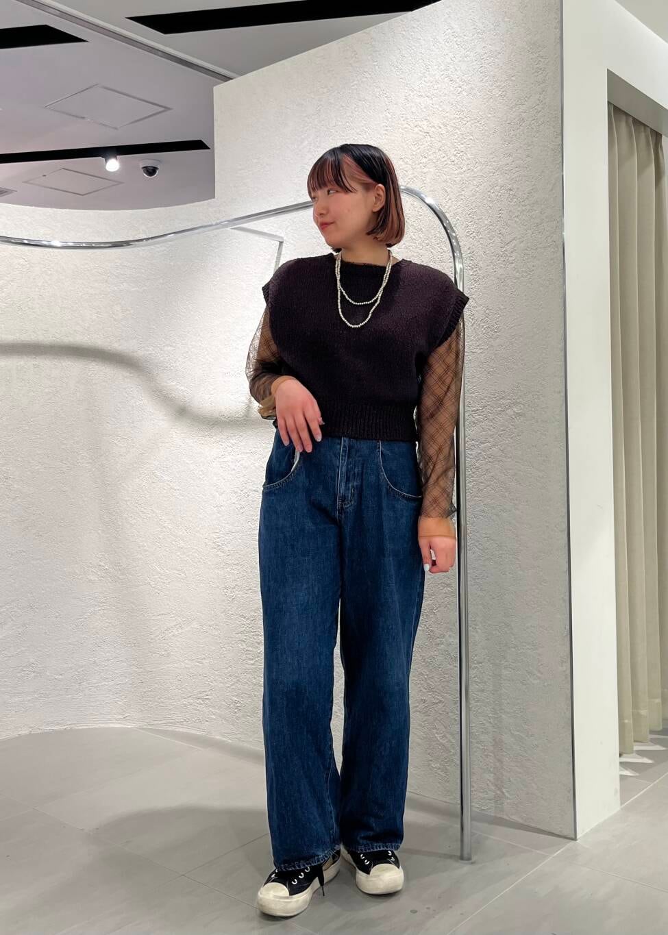 ブルー系のデニムパンツ、ブラック系のTシャツ/カットソー、ブラウン系のニット/セーターを着用したレディースの春コーディネートの2枚目の写真