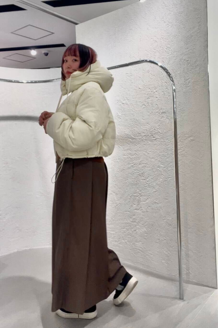 ホワイト系のダウンジャケット/コート、ブラウン系のニット/セーター、ブラウン系のワンピースを着用したレディースの冬コーディネートの2枚目の写真