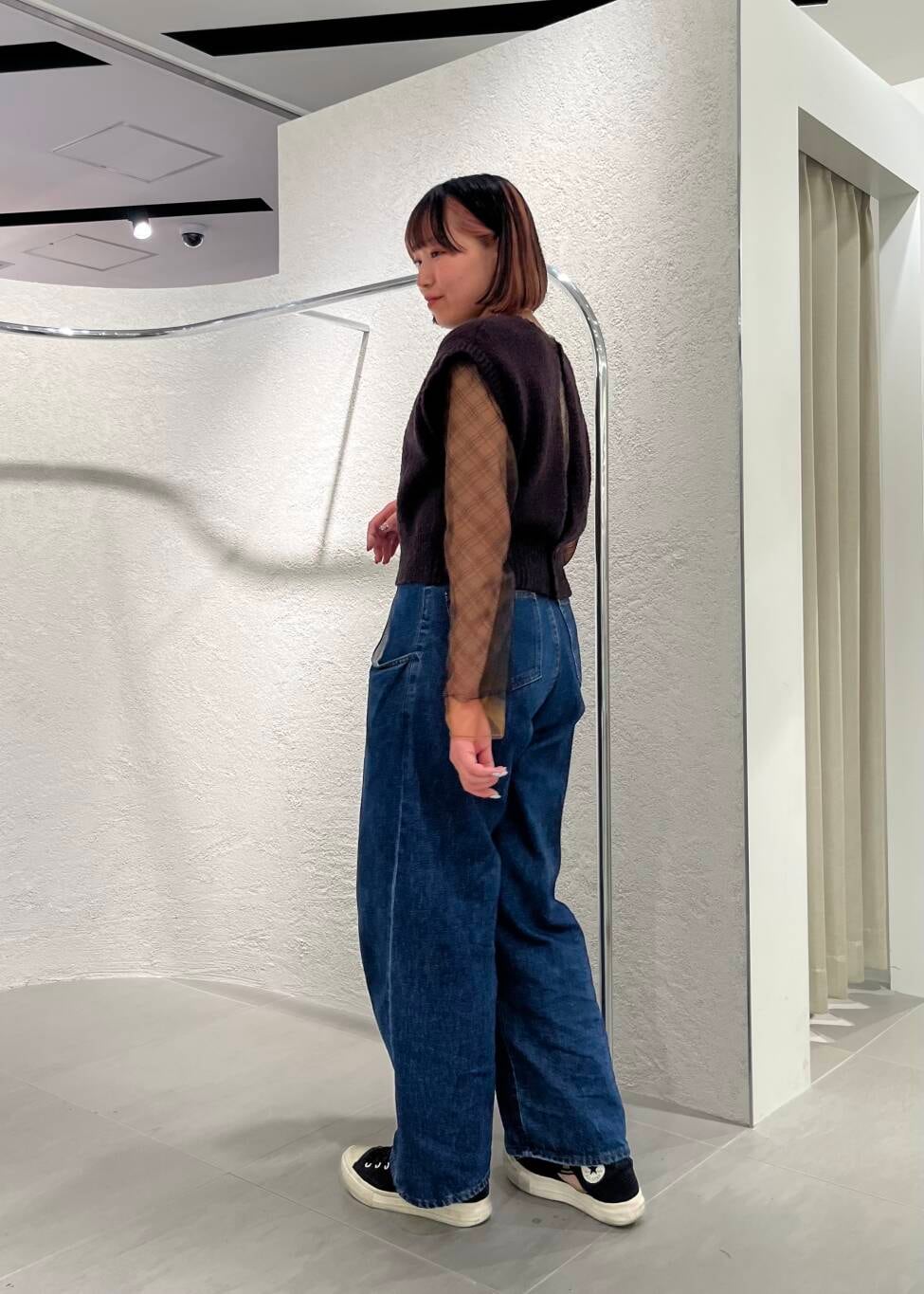 ブルー系のデニムパンツ、ブラック系のTシャツ/カットソー、ブラウン系のニット/セーターを着用したレディースの春コーディネートの3枚目の写真