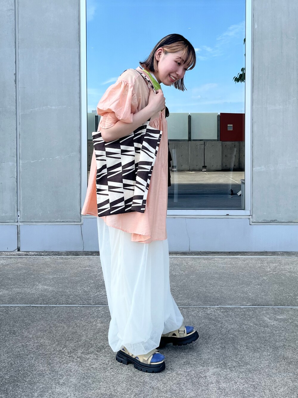 ホワイト系のその他パンツ、ベージュ系のサンダル、オレンジ系のワンピースを着用したレディースの夏コーディネートの2枚目の写真