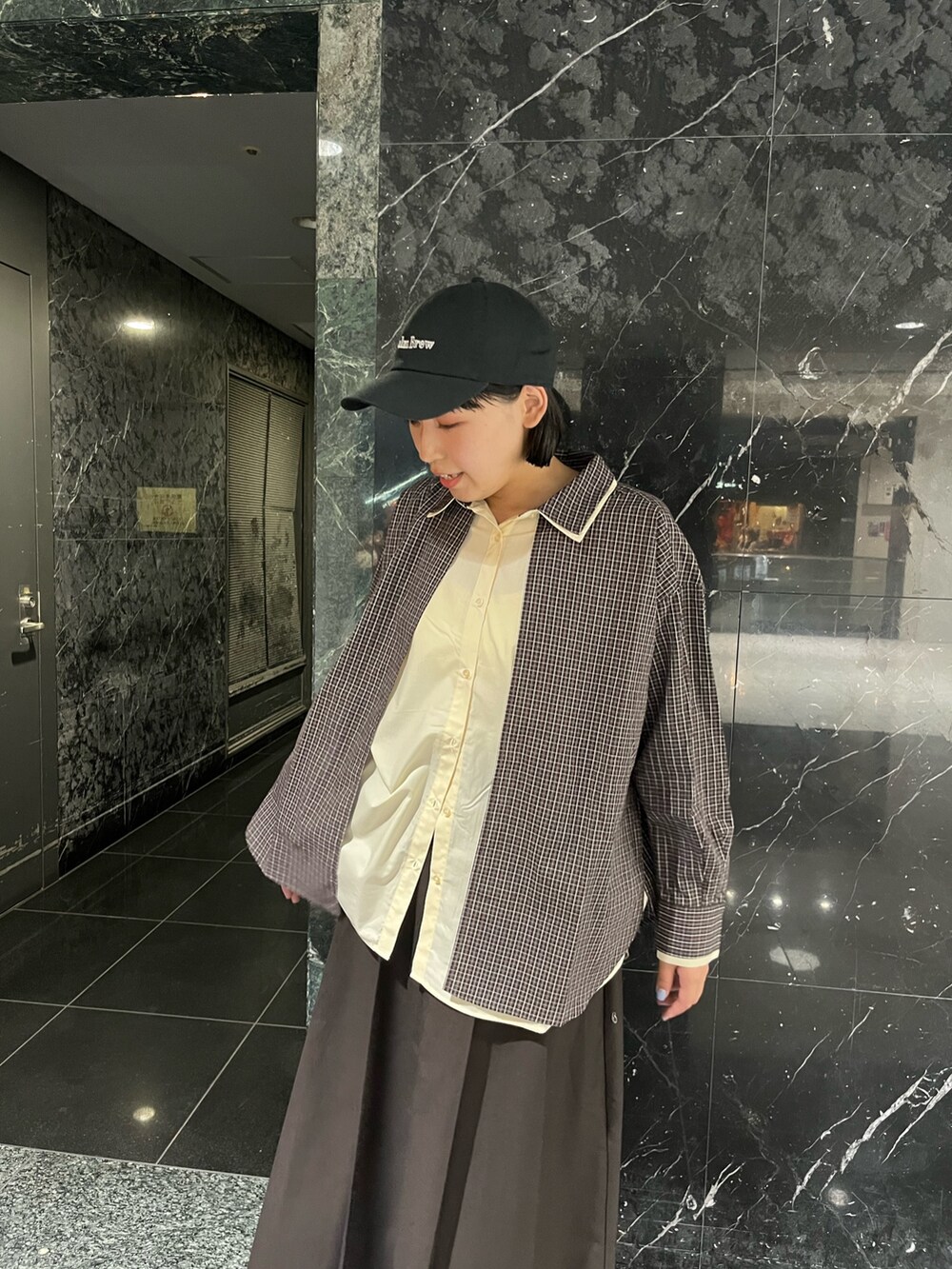 ブラウン系のシャツ/ブラウス、ブラウン系のワンピース、ブラック系のキャップを着用したレディースの秋コーディネートの3枚目の写真