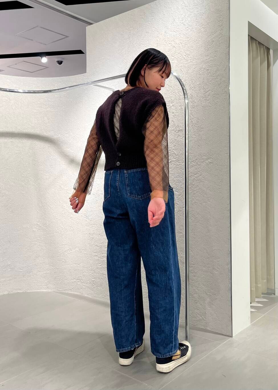 ブルー系のデニムパンツ、ブラック系のTシャツ/カットソー、ブラウン系のニット/セーターを着用したレディースの春コーディネートの4枚目の写真