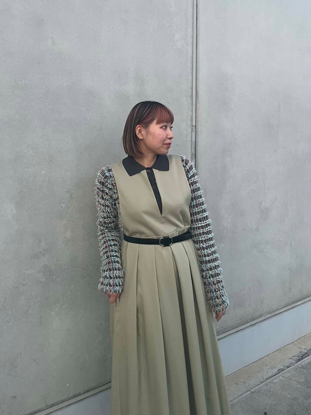 グレー系のニット/セーター、グリーン系のワンピース、ブラック系のベルトを着用したレディースの冬コーディネートの4枚目の写真