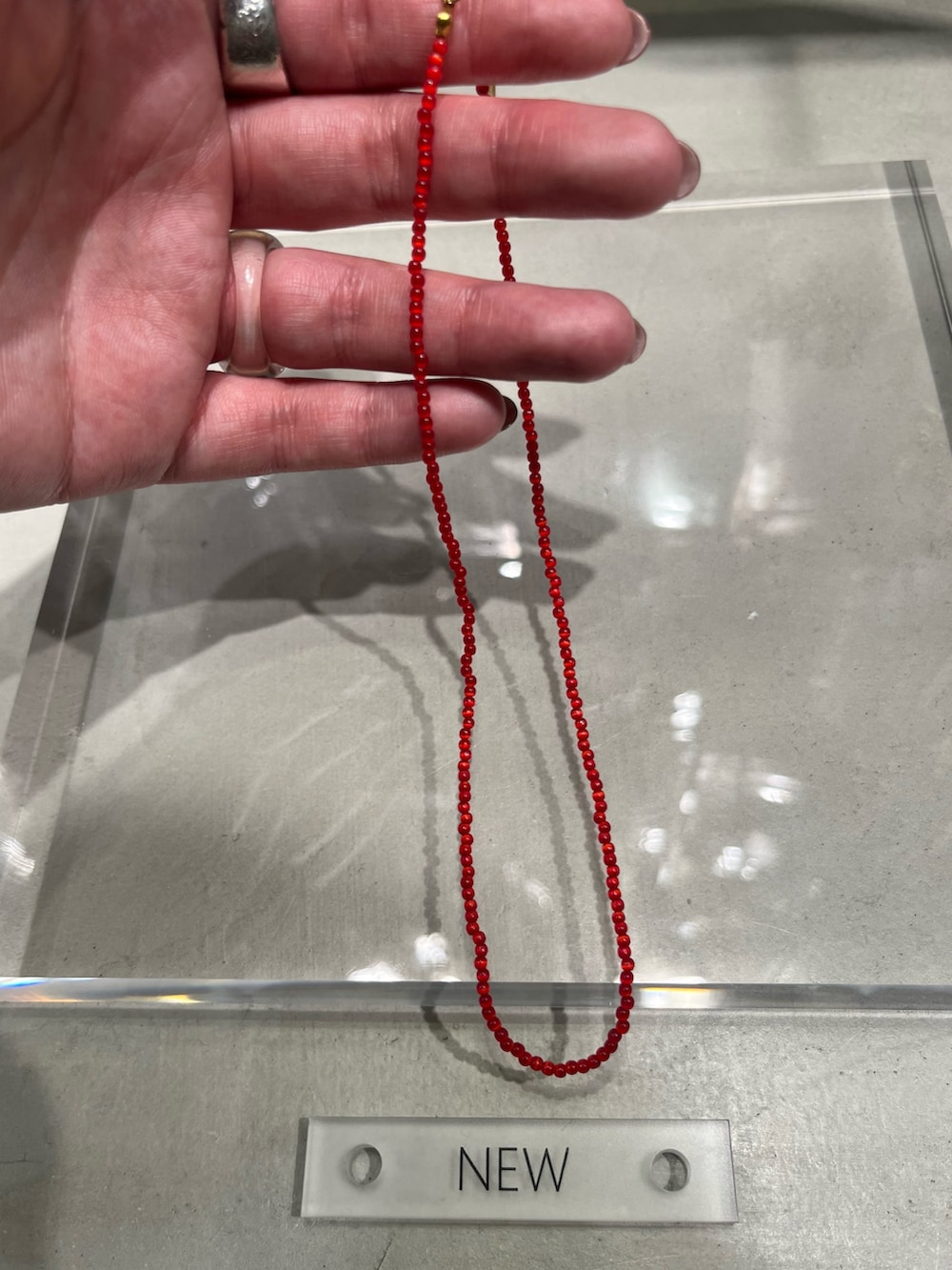 レッド系のネックレスを着用したレディースの冬コーディネートの2枚目の写真