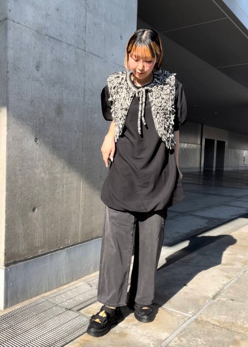 ブラック系のサンダル、ブラック系のベスト、ブラック系のデニムパンツを着用したレディースの夏コーディネートの2枚目の写真