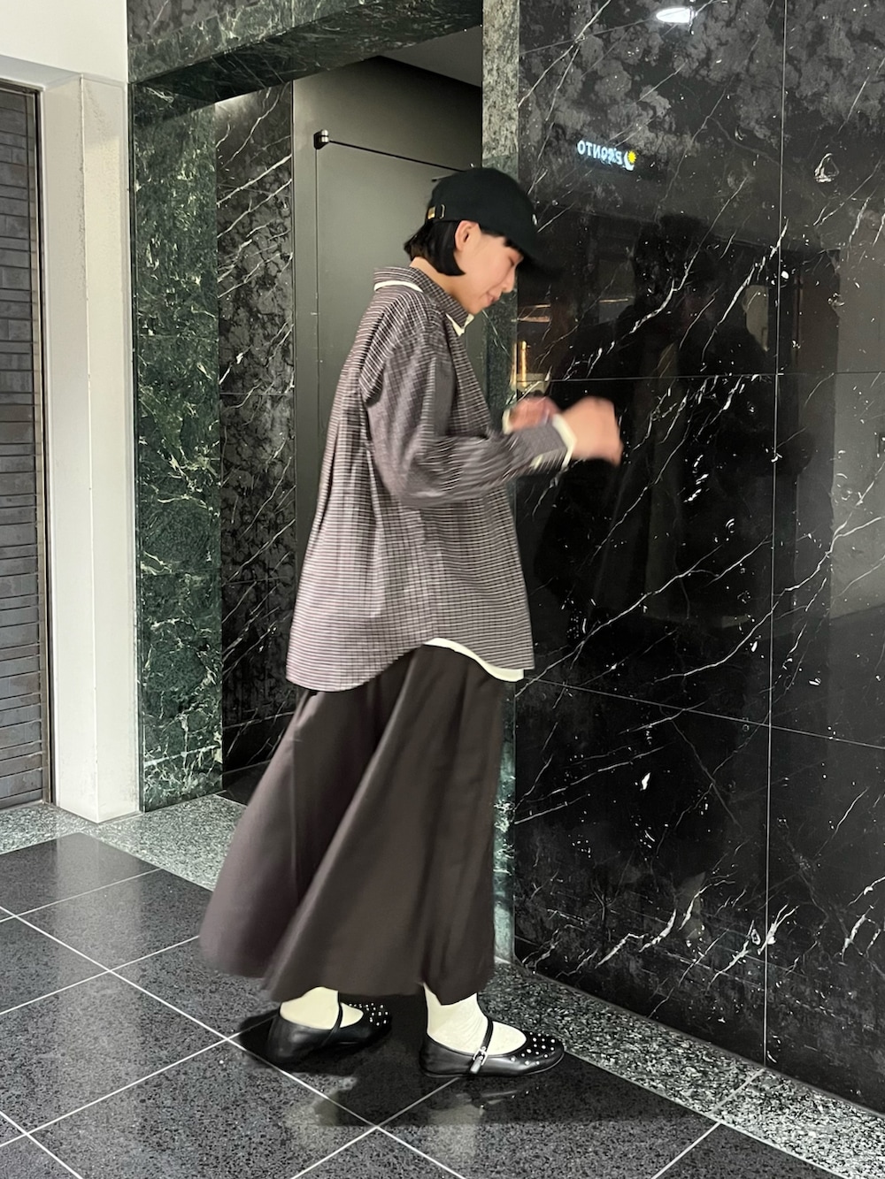 ブラウン系のシャツ/ブラウス、ブラウン系のワンピース、ブラック系のキャップを着用したレディースの秋コーディネートの2枚目の写真