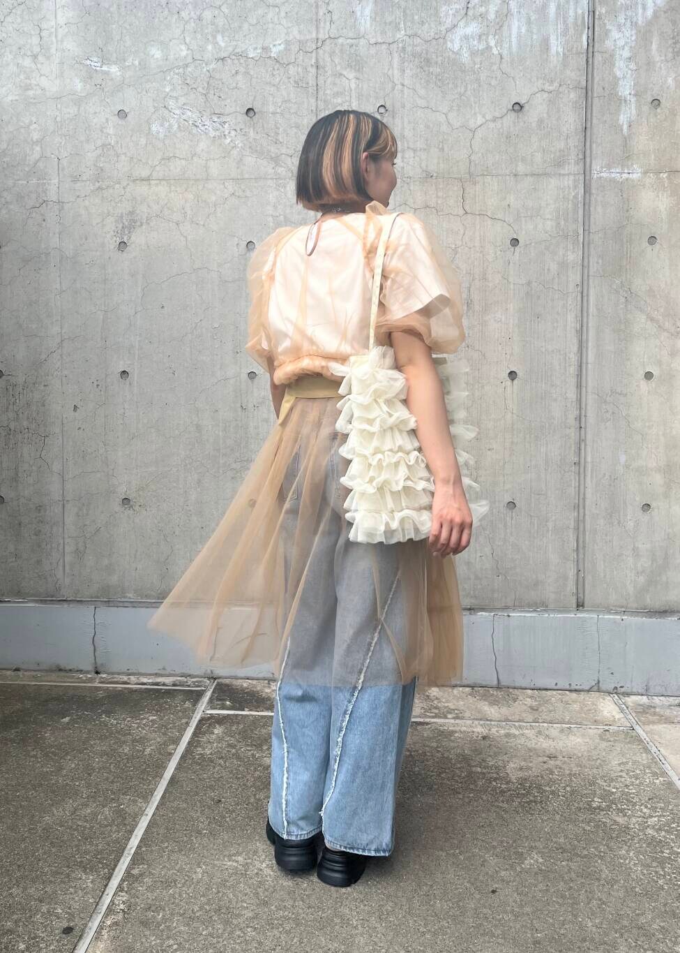 ブルー系のデニムパンツ、ホワイト系のトートバッグ、ブラック系のサンダルを着用したレディースの夏コーディネートの2枚目の写真