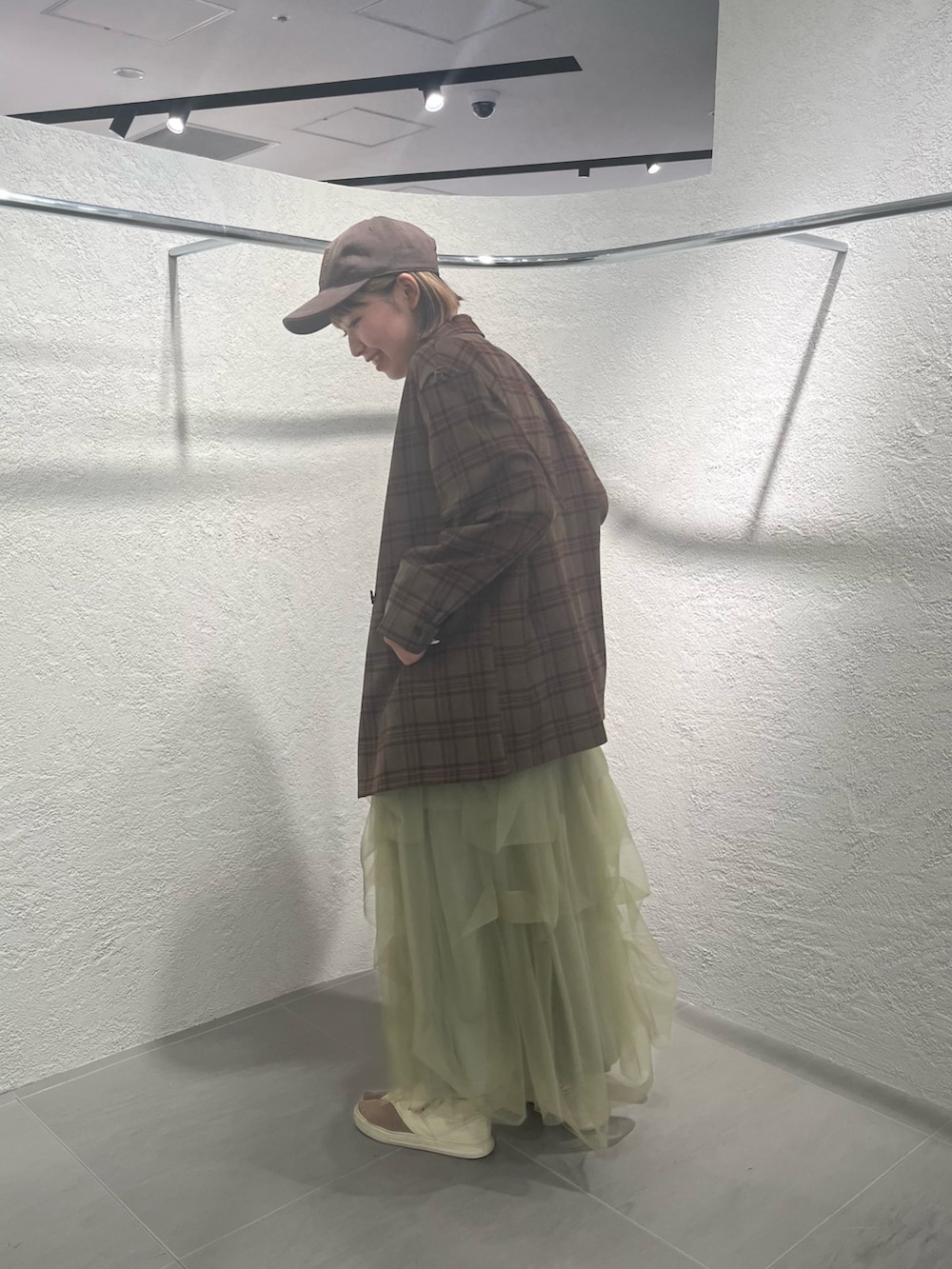 グリーン系のスカート、レッド系のその他アウター、ホワイト系のTシャツ/カットソーを着用したレディースの秋コーディネートの2枚目の写真