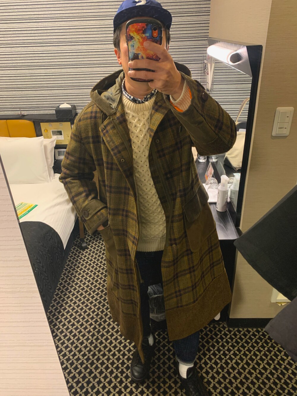 グリーン系のモッズコート、ホワイト系のニット/セーター、ブルー系のデニムパンツを着用したメンズの冬コーディネートの3枚目の写真