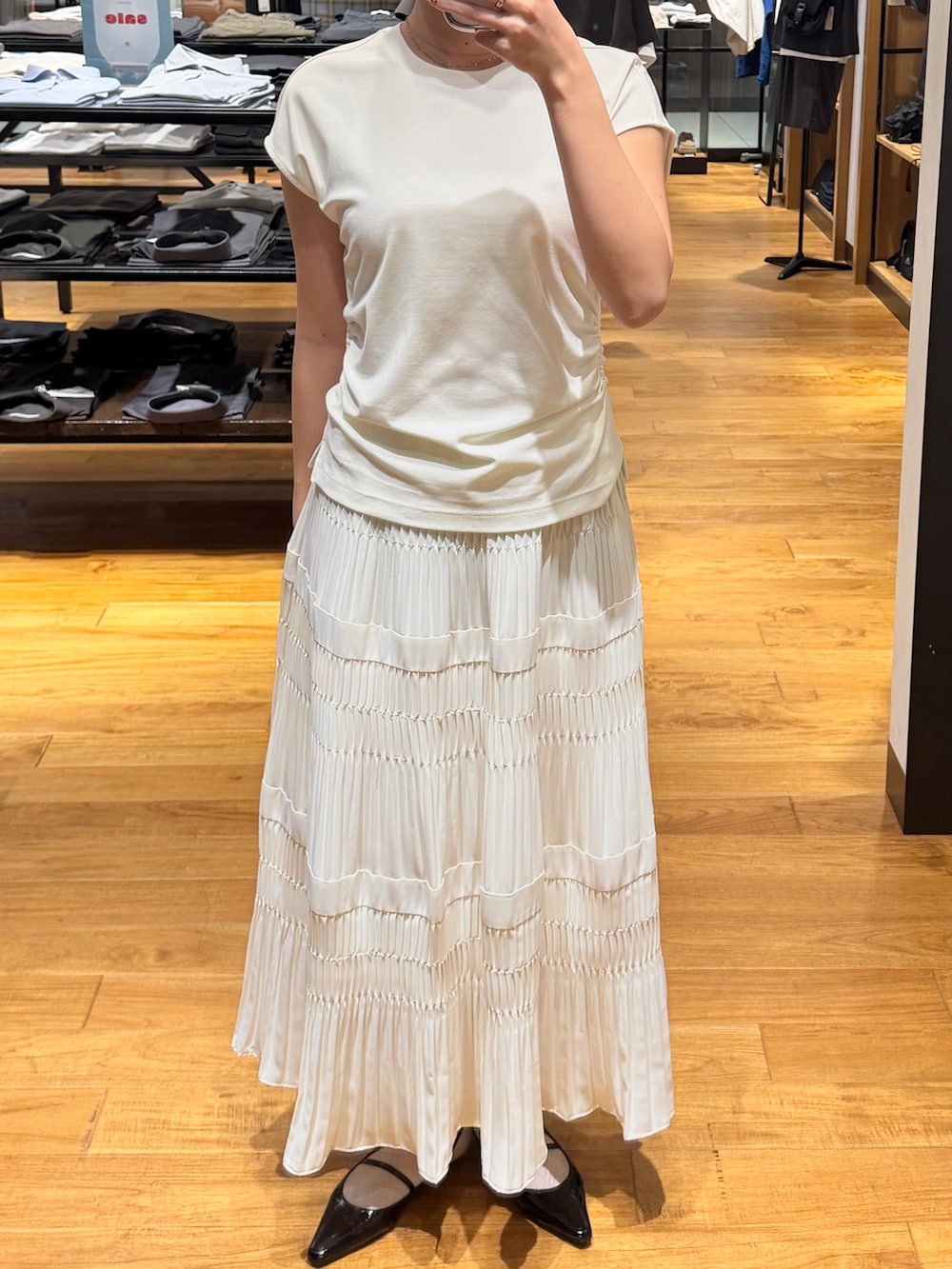 ブラック系のパンプス、ホワイト系のスカート、ホワイト系のTシャツ/カットソーを着用したレディースの夏コーディネートの2枚目の写真