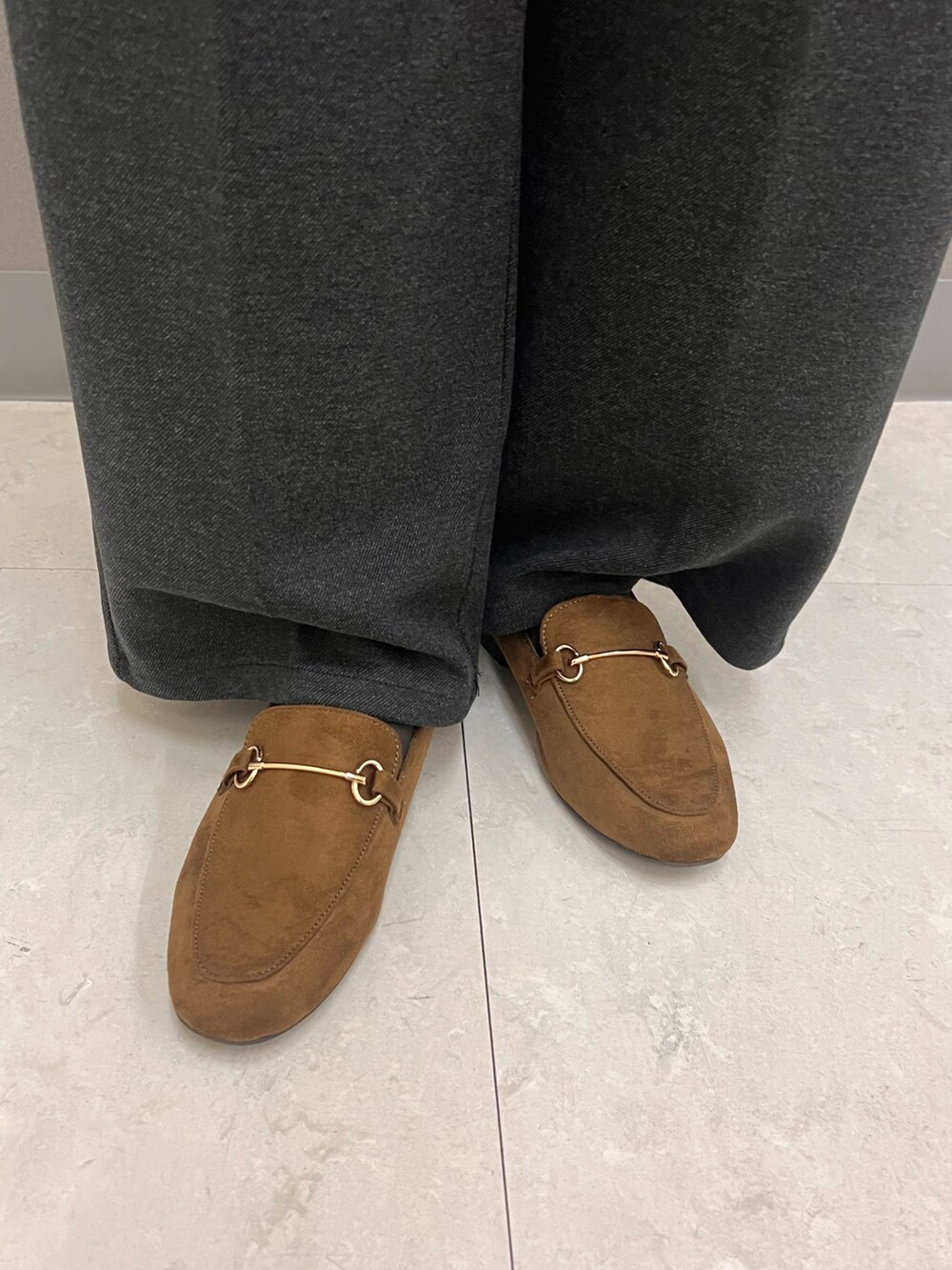 グレー系のニット/セーター、ベージュ系のダウンジャケット/コート、ベージュ系のボストンバッグを着用したレディースの秋コーディネートの4枚目の写真