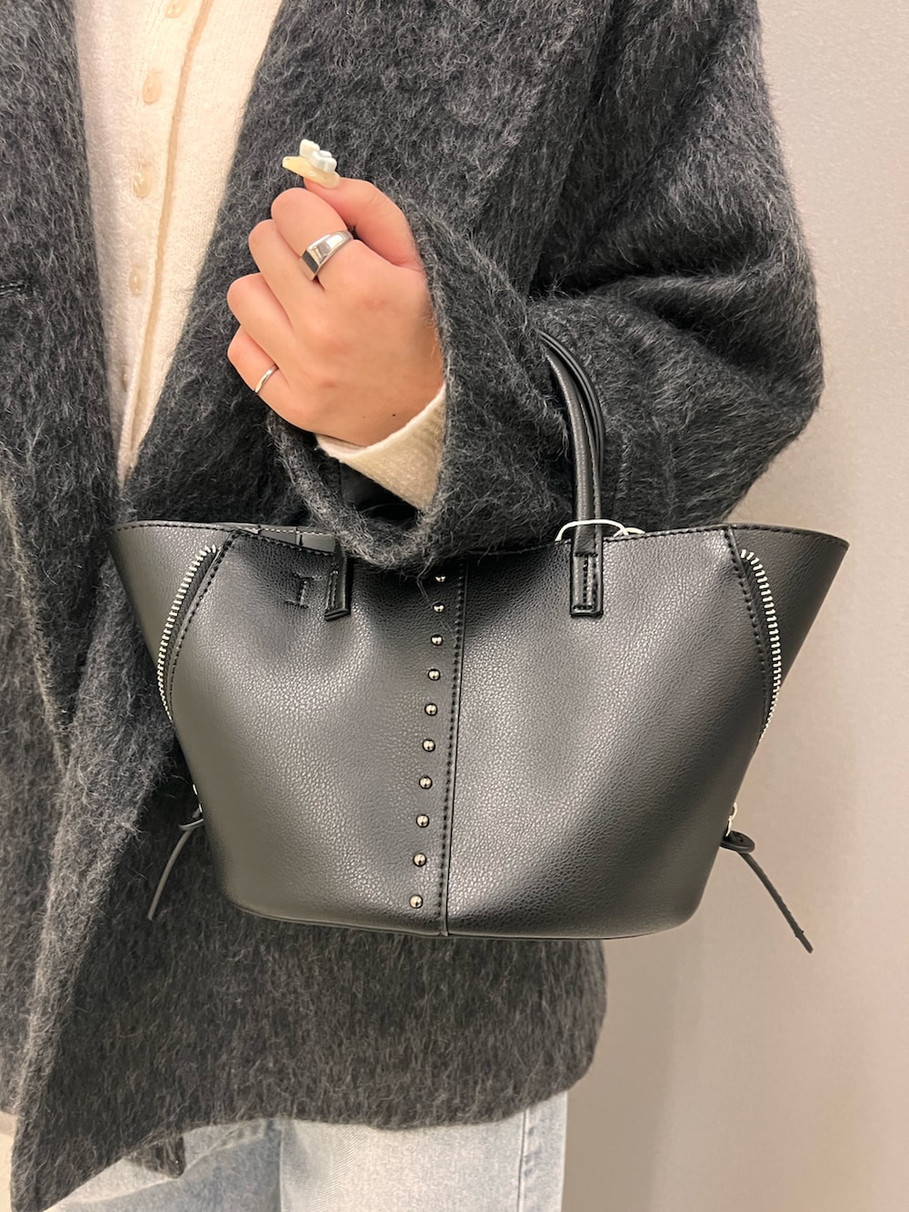 ホワイト系のニット/セーター、グレー系のその他アウター、ブラック系のショルダーバッグを着用したレディースの秋コーディネートの4枚目の写真