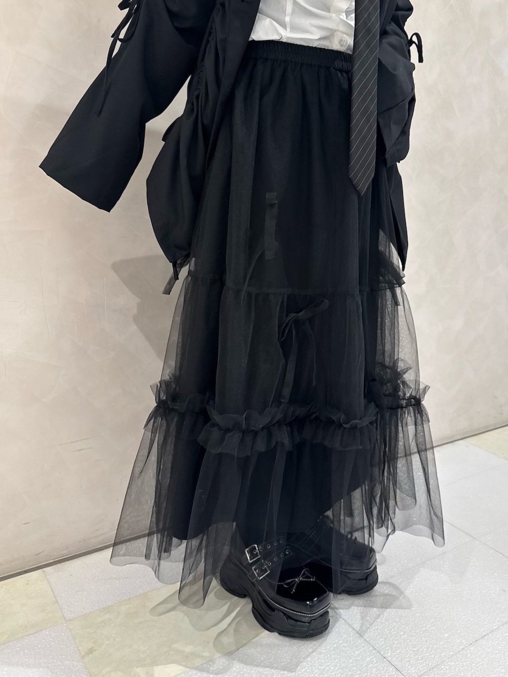 ブラック系のテーラードジャケット、ホワイト系のシャツ/ブラウス、ブラック系のネクタイを着用したレディースの秋コーディネートの6枚目の写真