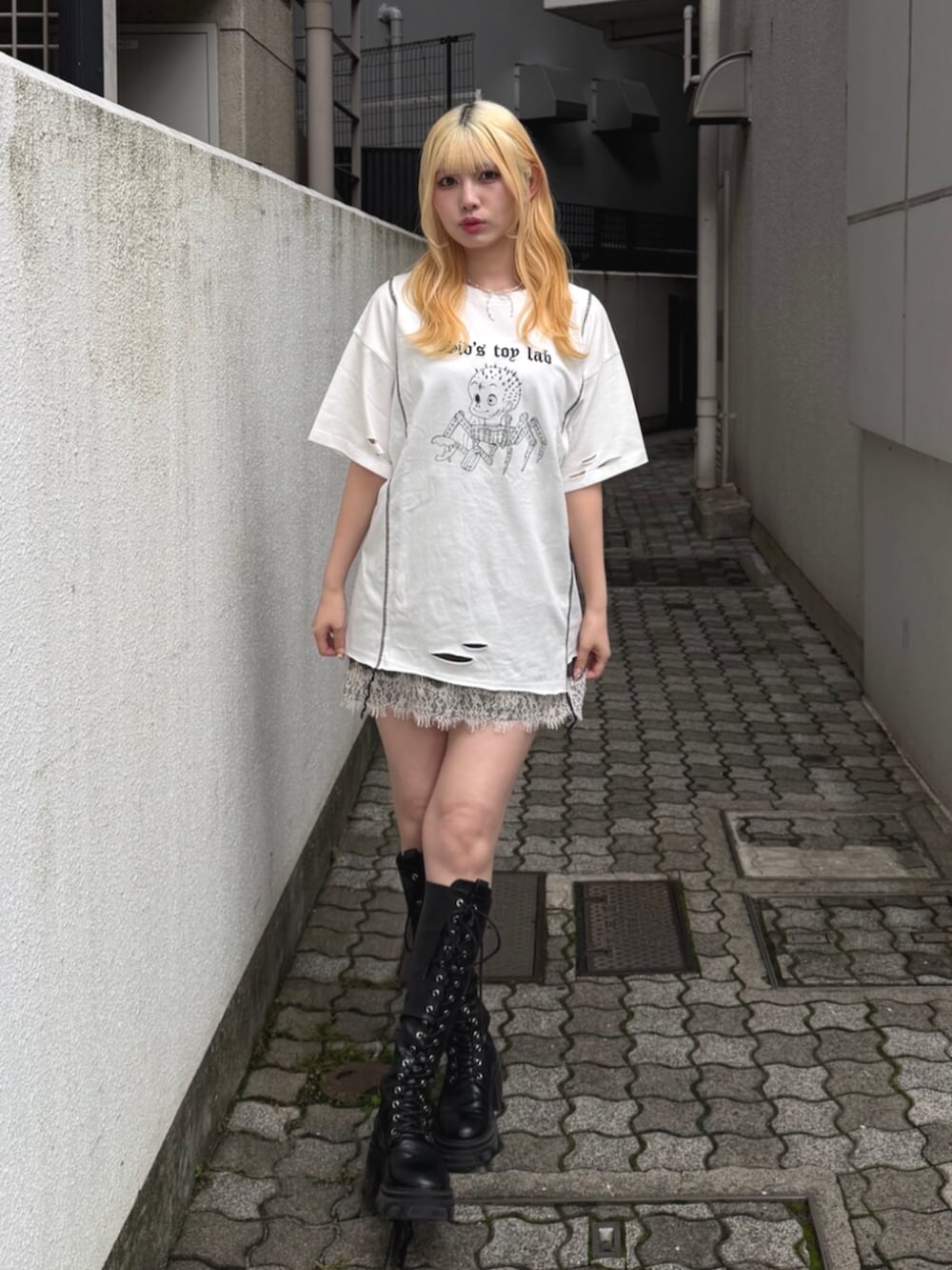 ブラック系のブーツ、ホワイト系のTシャツ/カットソー、ブラック系のワンピースを着用したレディースの夏コーディネートの2枚目の写真